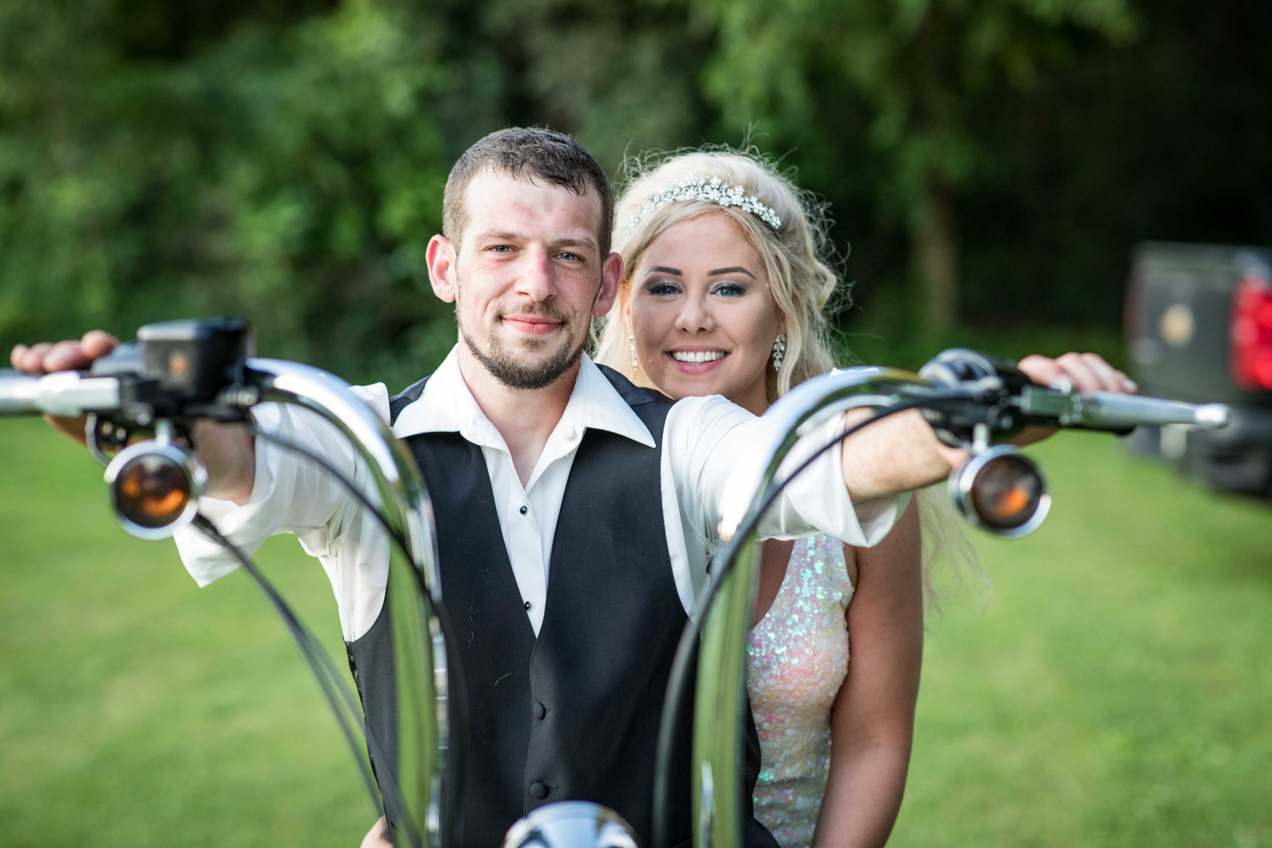  The Bride and Groom pose for a photo on the motorcycle before riding off together. 