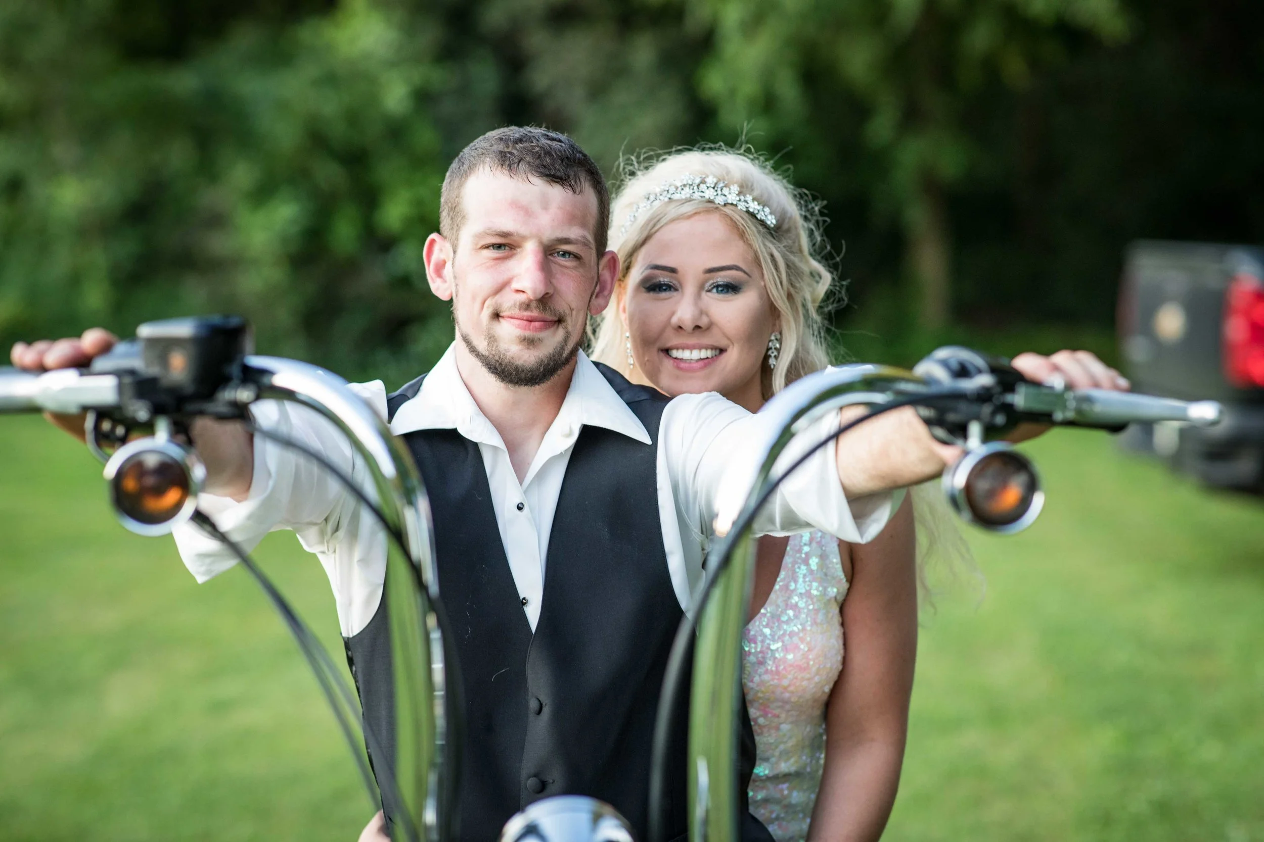 The Bride and Groom pose for a photo on the motorcycle before riding off together.