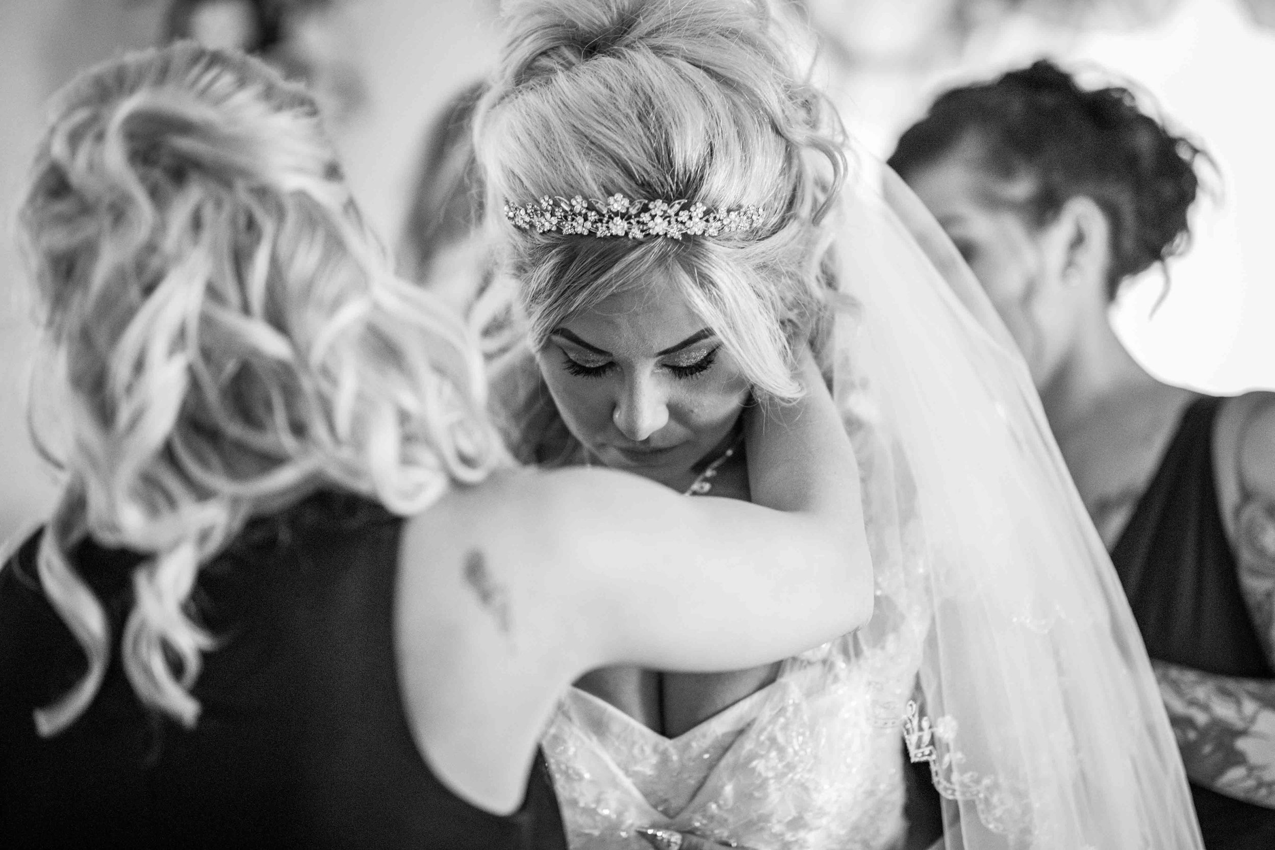  a friend puts a necklace around the bride 