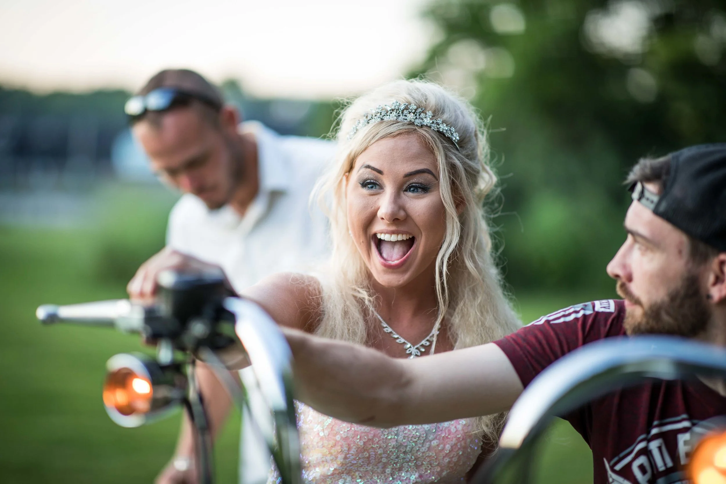 The Bride looks excited as she revs the engine of a motorcycle