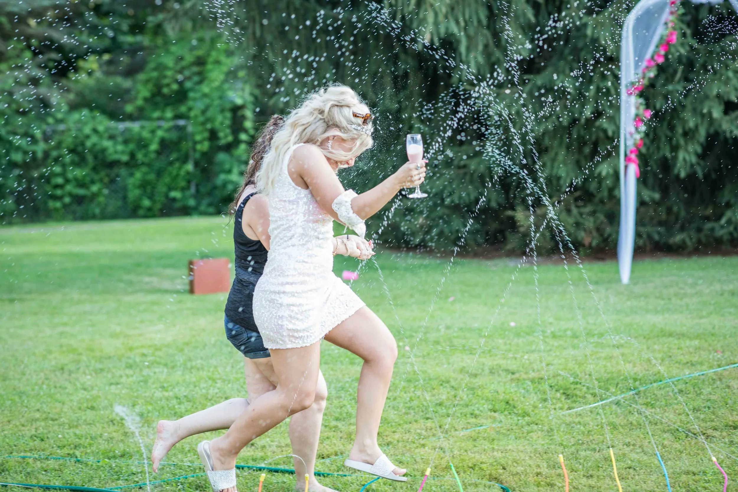 Bride running through a sprinkler system