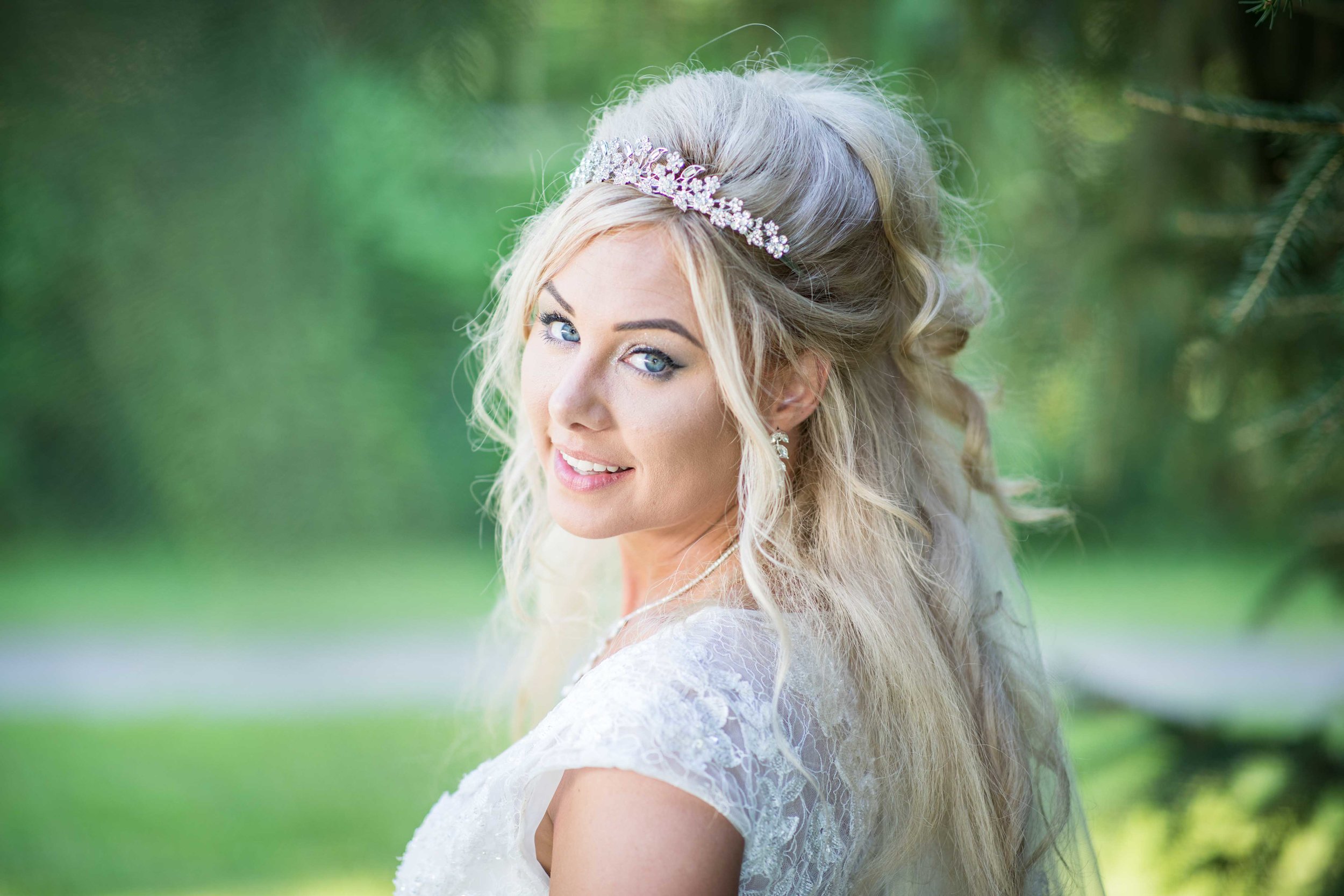  The Bride poses for a photo near an evergreen 