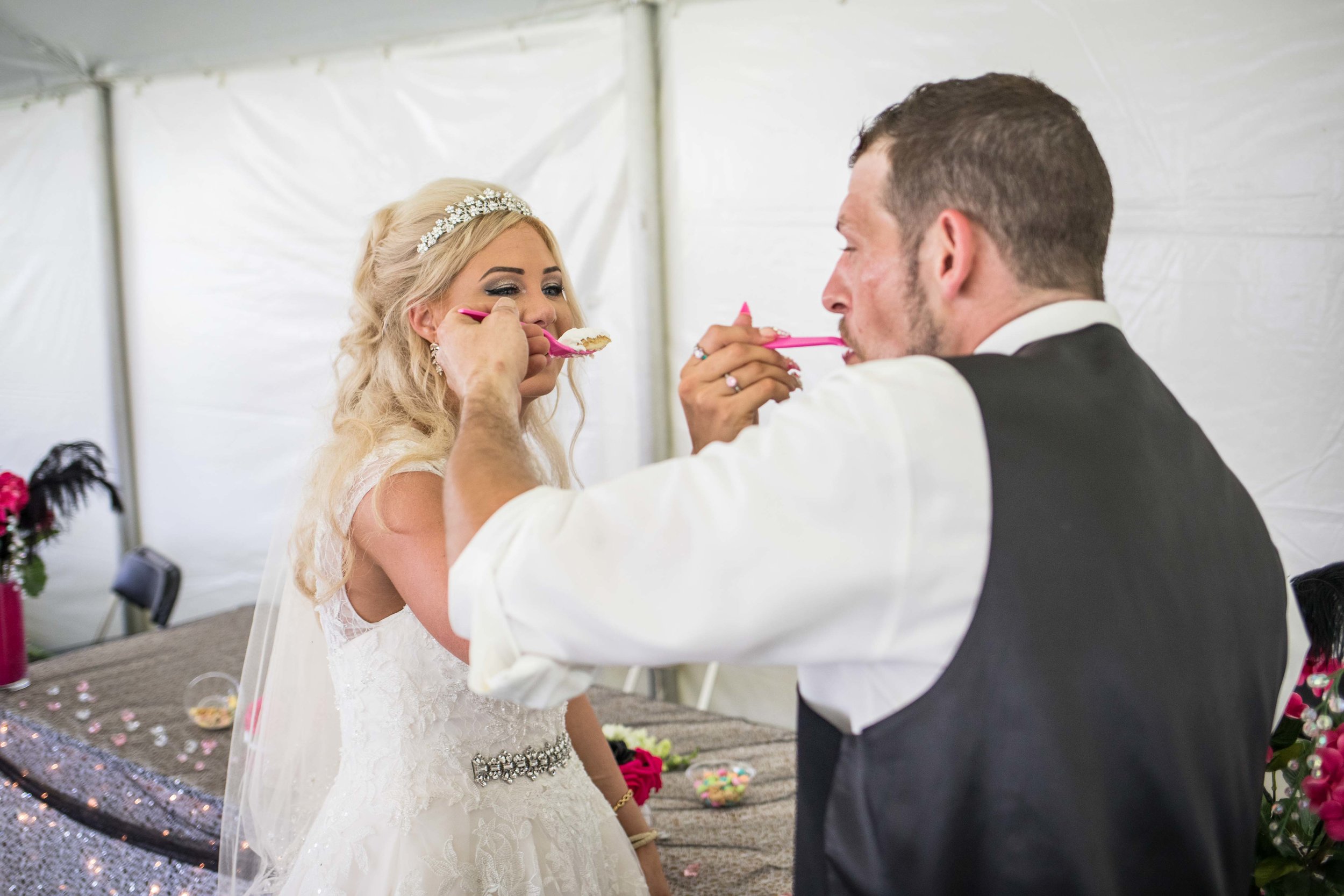  husband and wife feed each other cake 