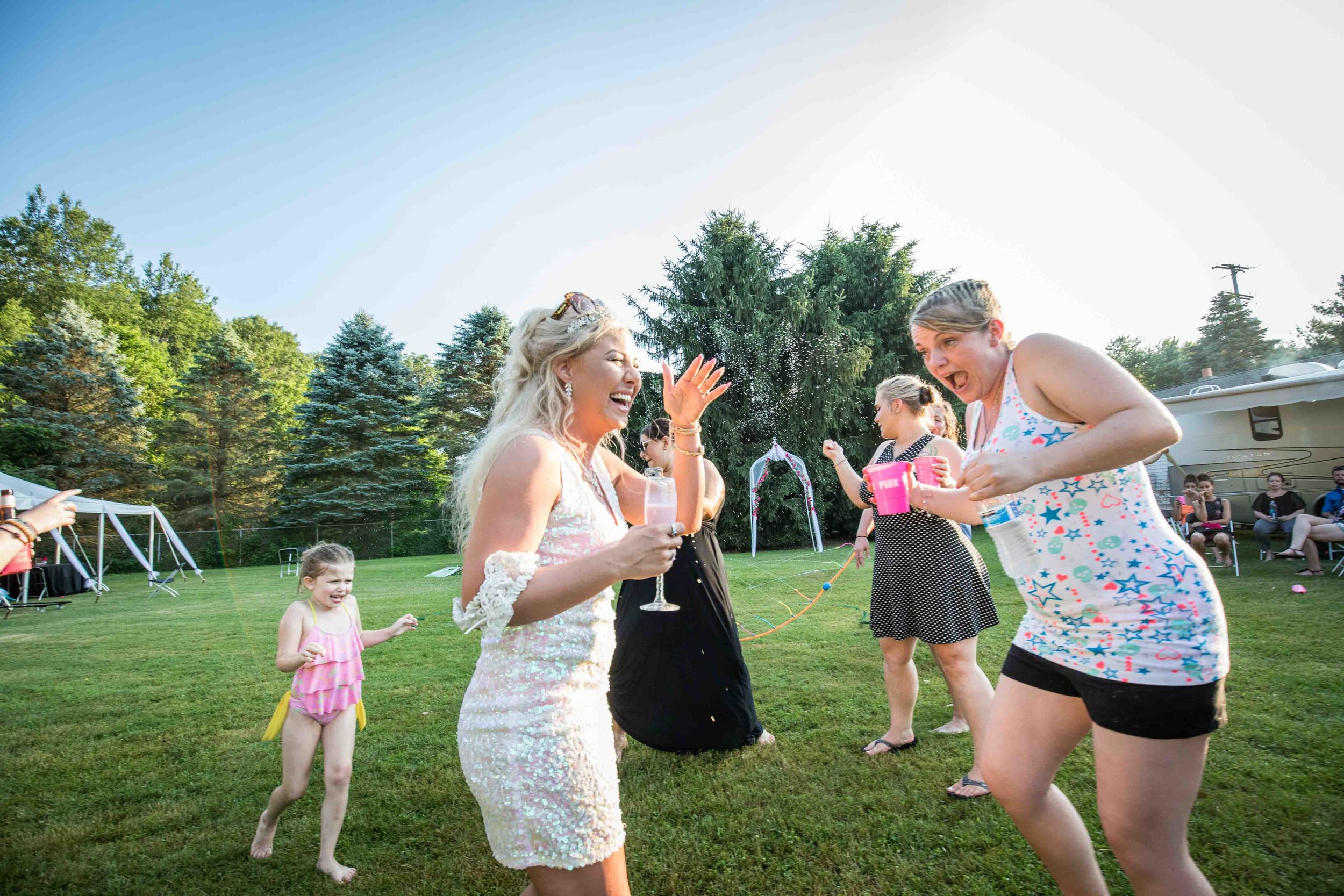  bride and friends dance in the water 