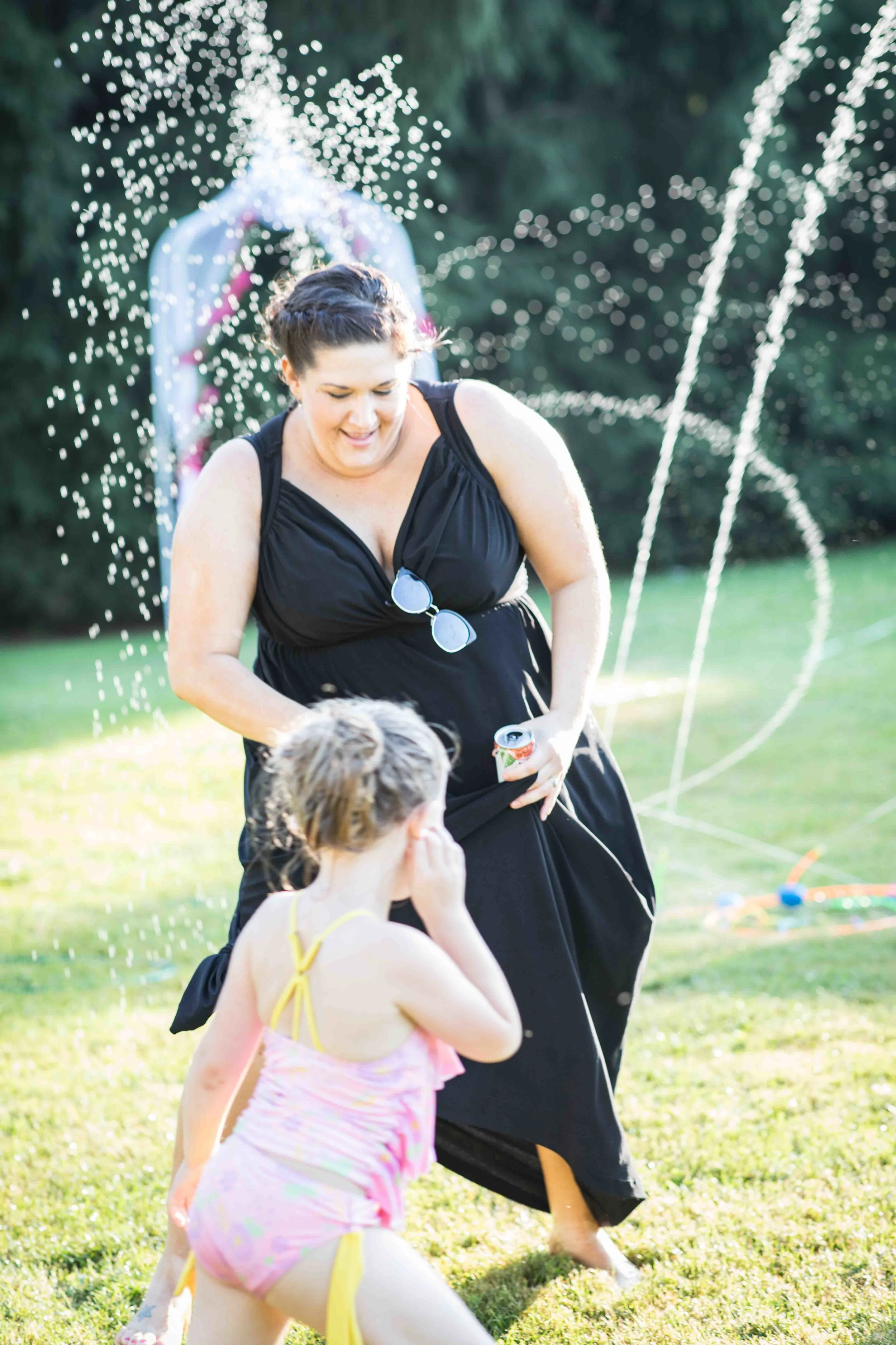 a bridesmaid gets soaked dancing with a little girl in the water