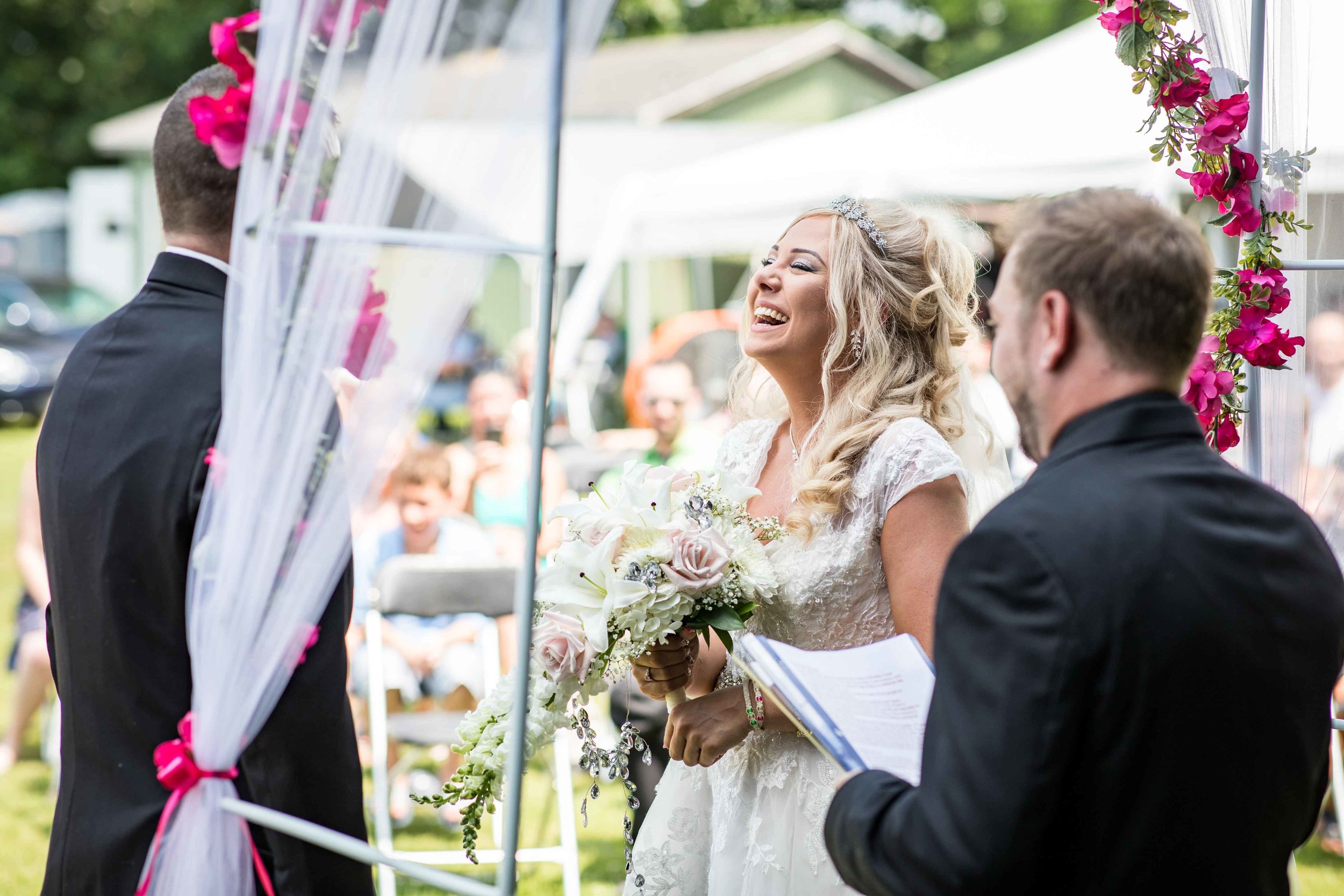  The bride laughs at a joke from the officiant  