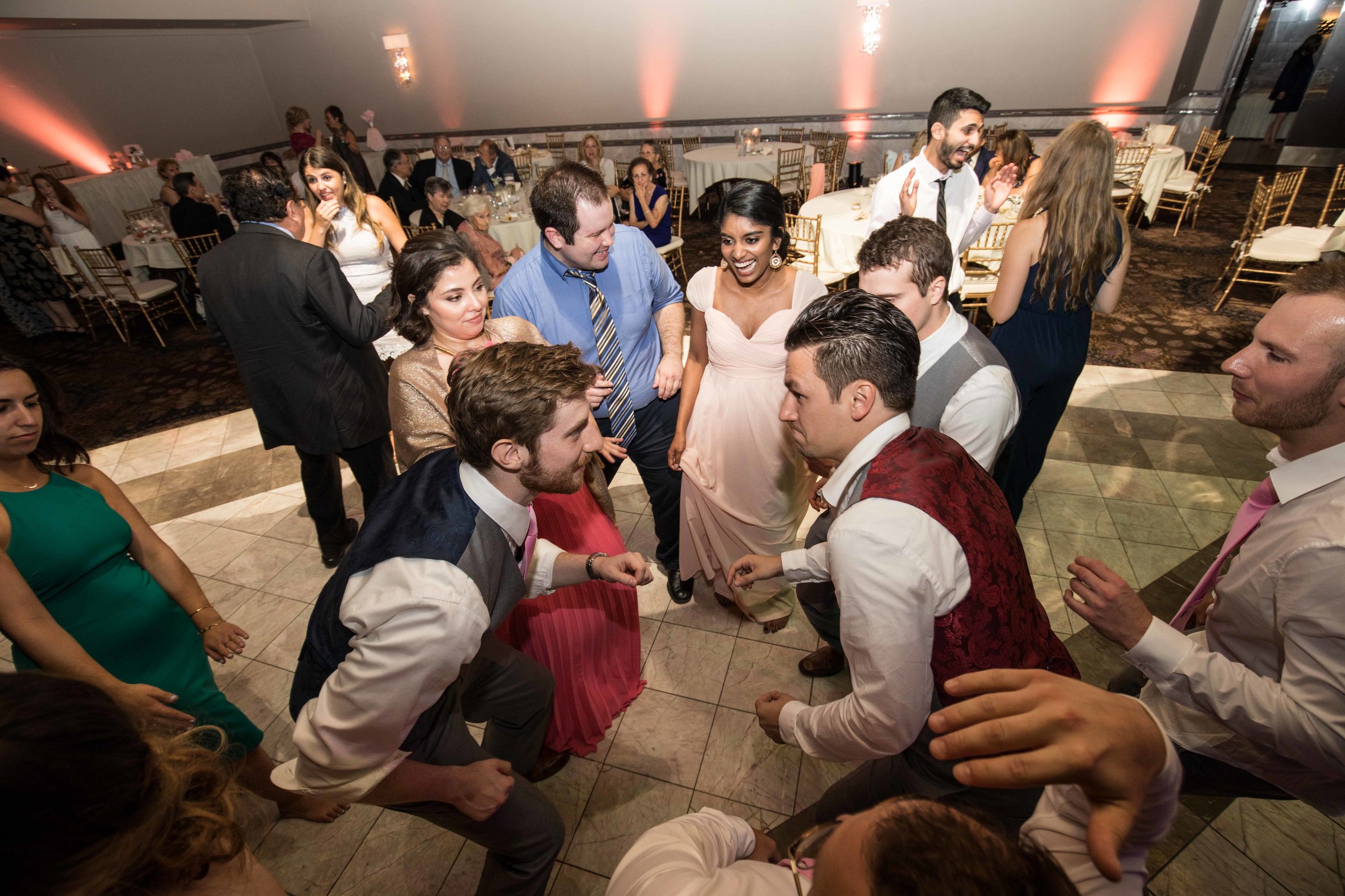  groom dancing with groomsmen and wedding guests 