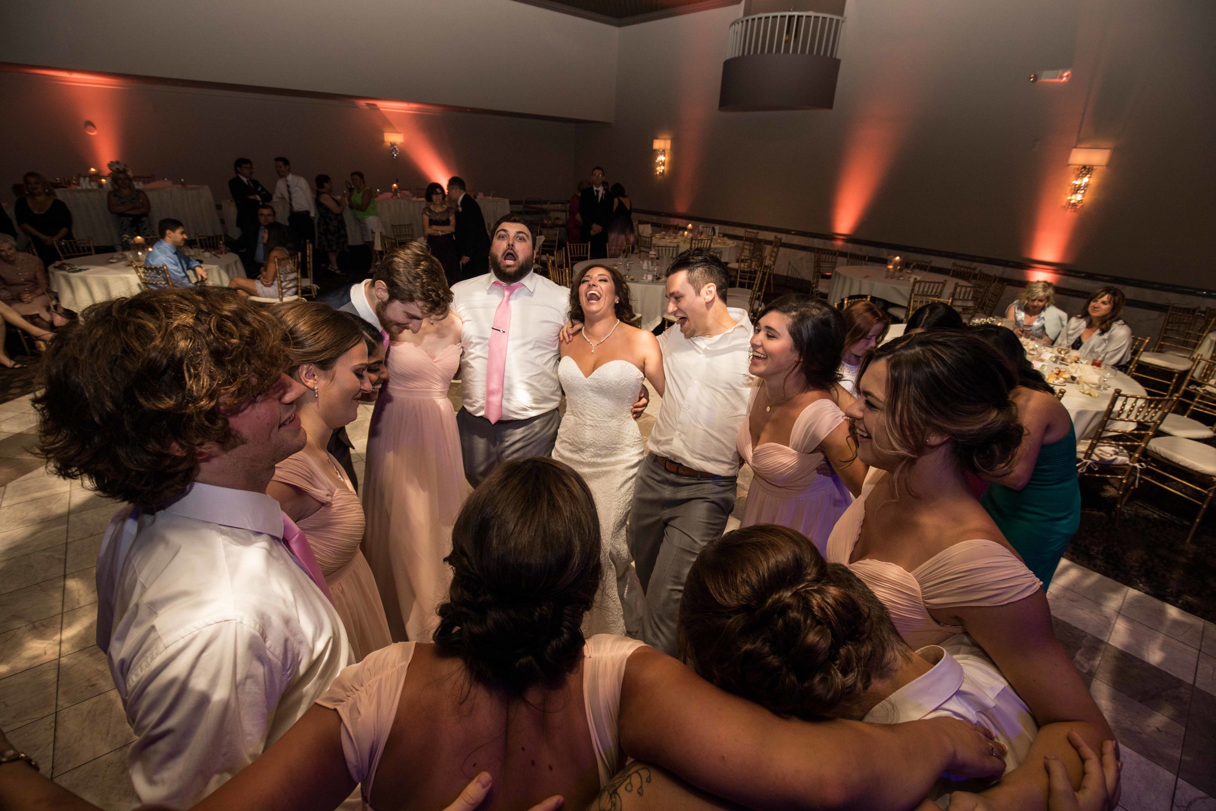  wedding party forms a circle on the dance floor 