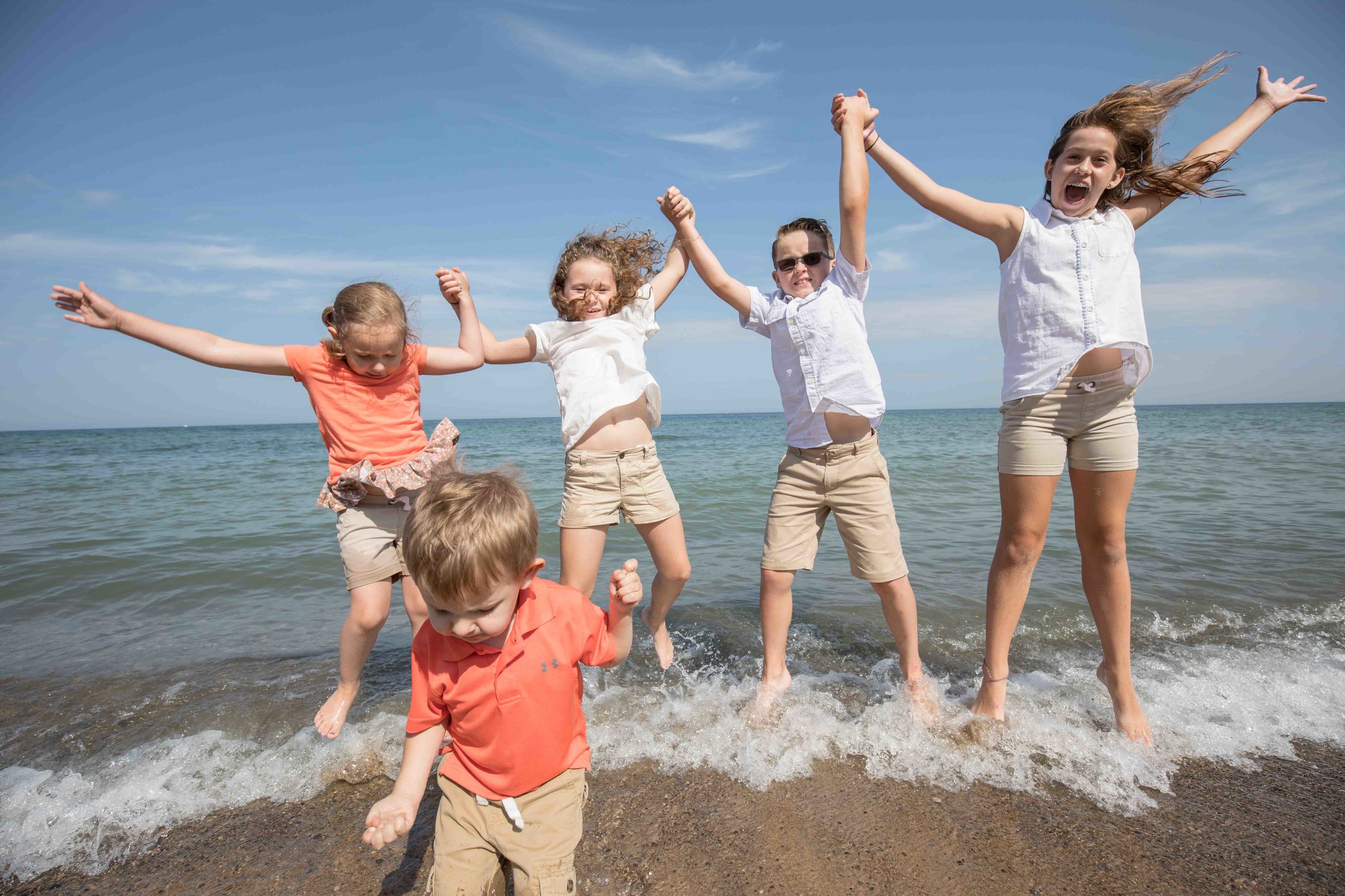  grand children jumping in lake michigan 