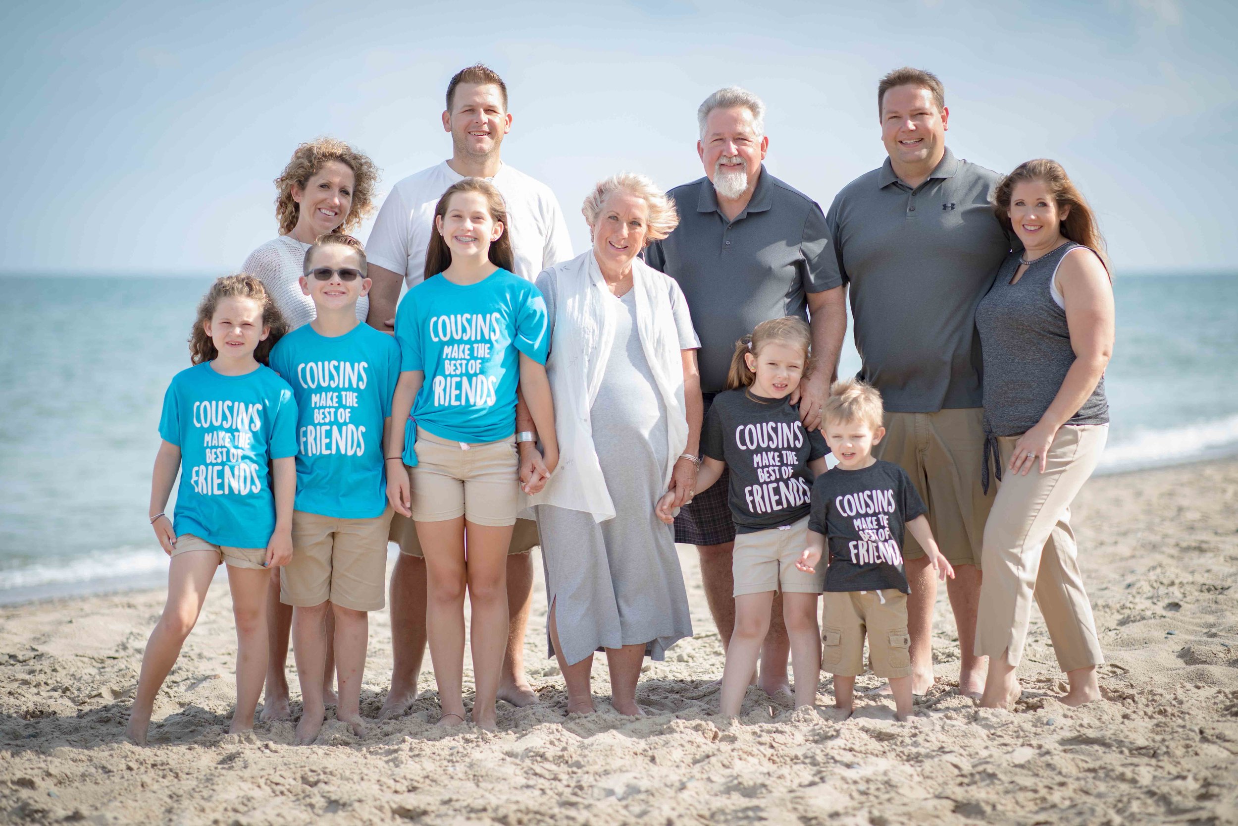  Entire family on a sunny beach with a blue Lake Michigan behind them 