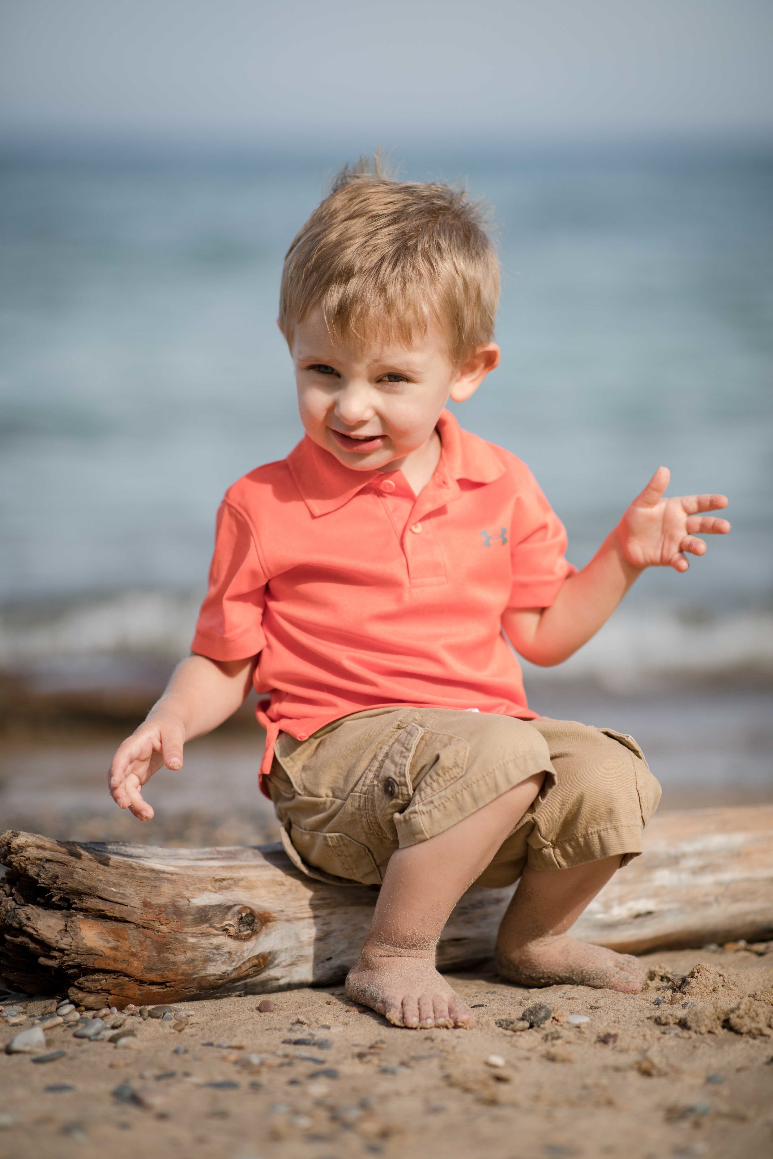  individual portrait of grand child sitting on a piece of driftwood 