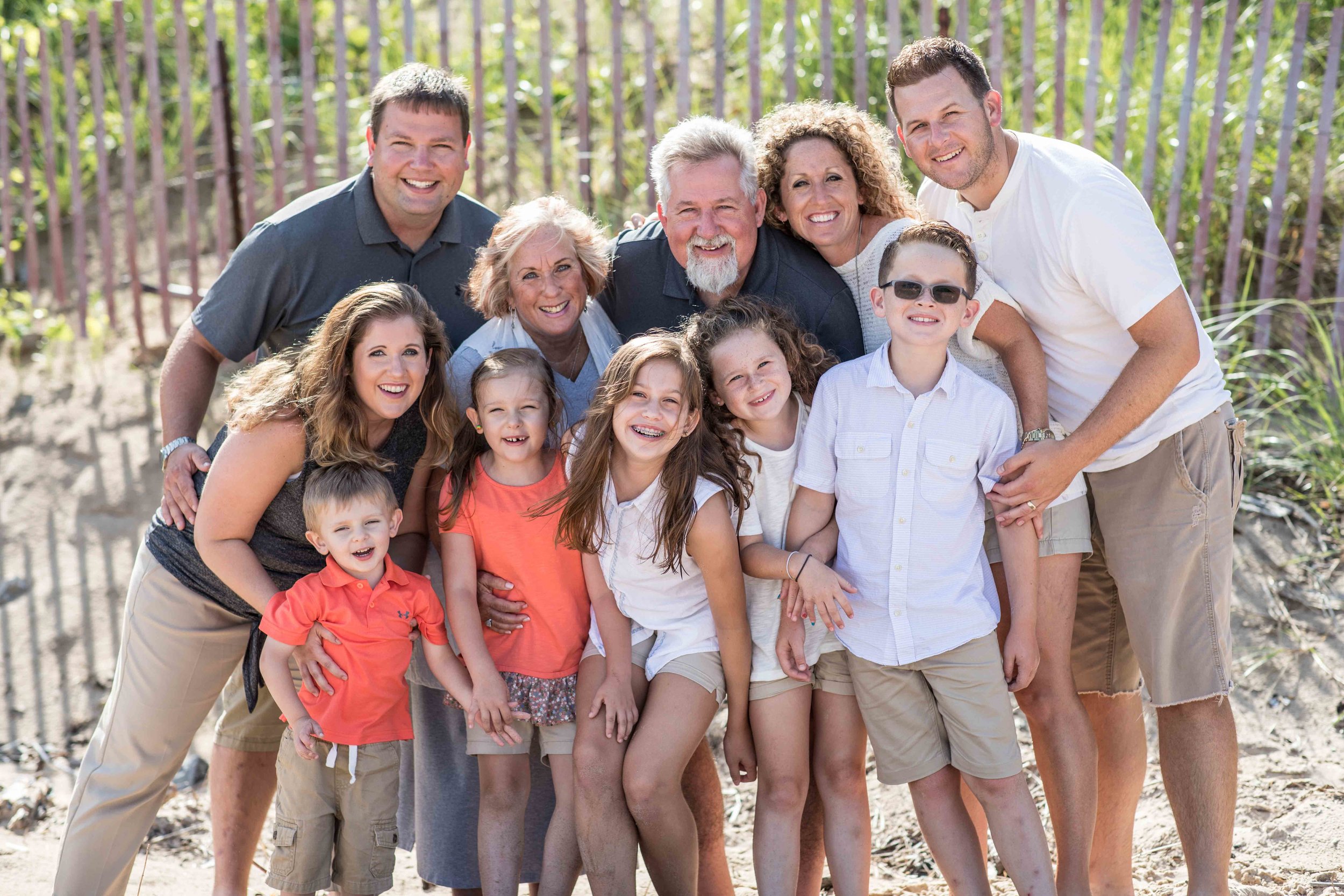  large group photo of family in front of beach fence 