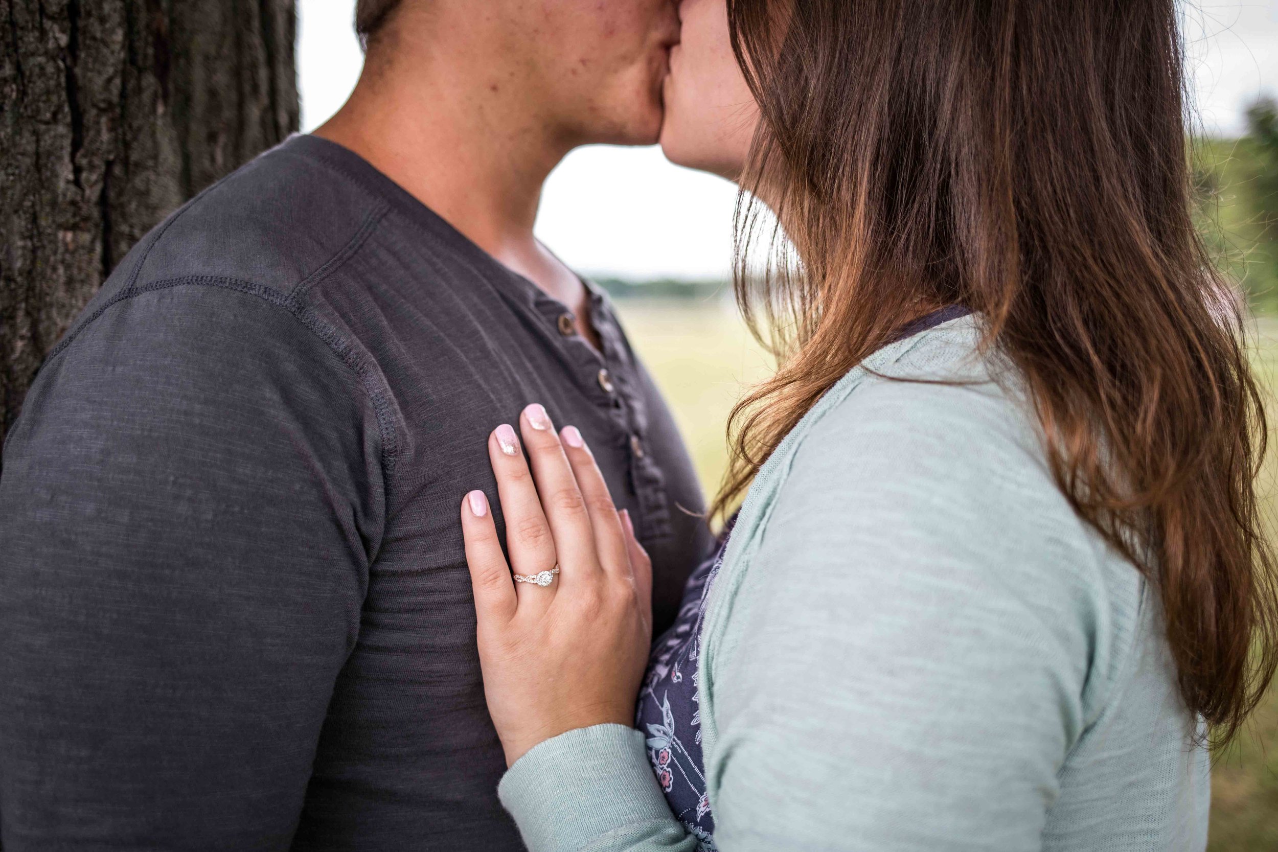  she places her new ring hand on his chest as they kiss 