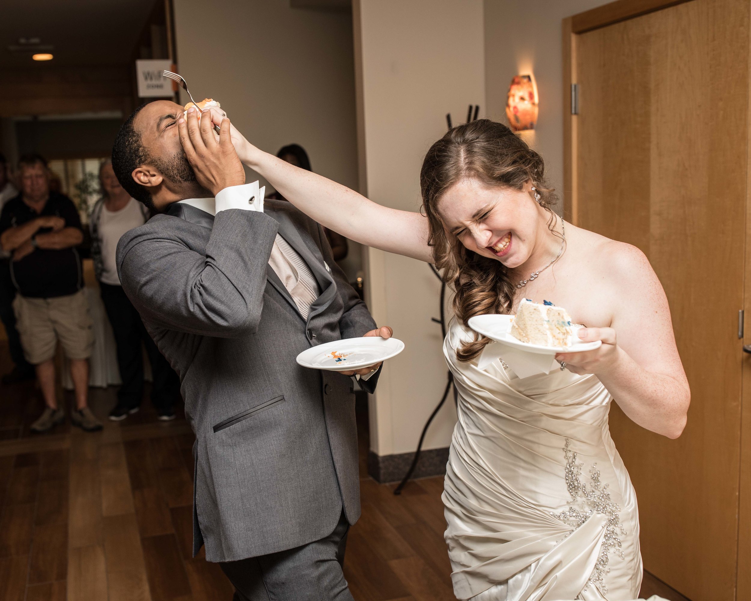  the bride smashes cake in the groom’s face during cake cutting 