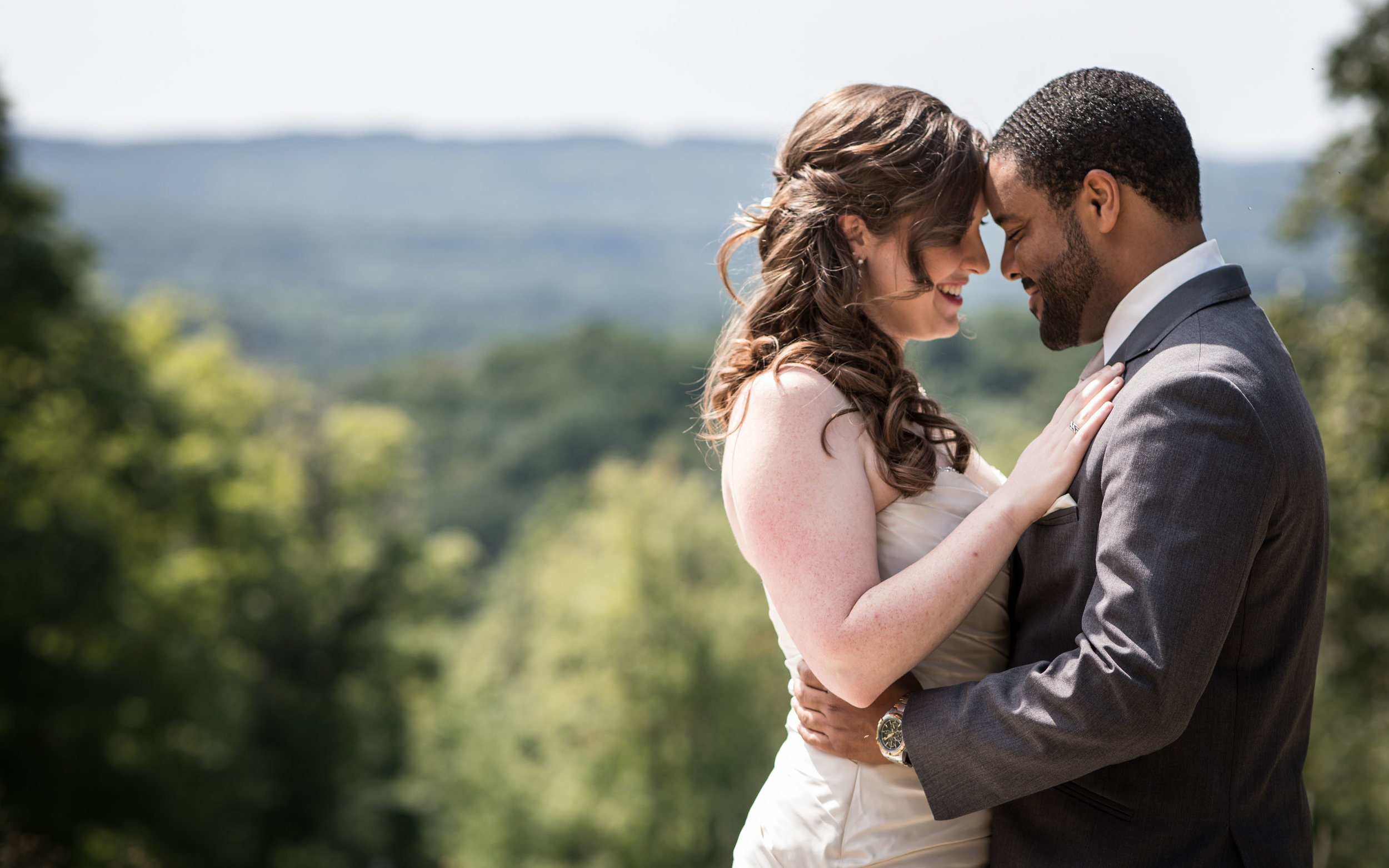  bride and groom hold each other with a mountainous backdrop 