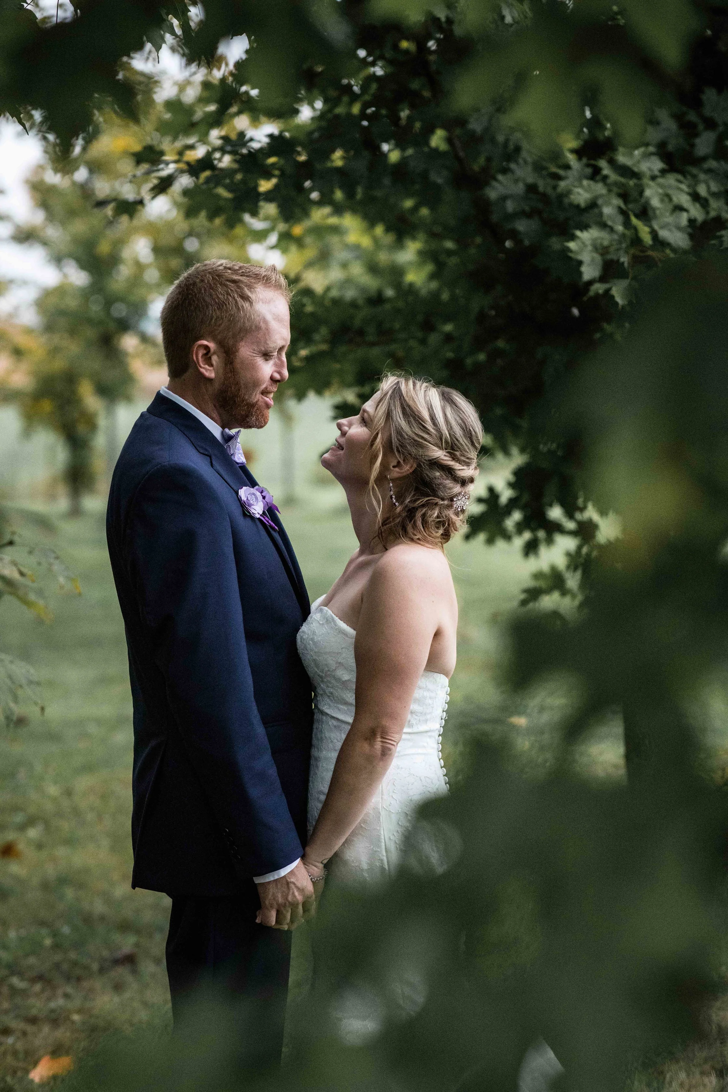 bride and groom portrait photographed through the trees during golden hour