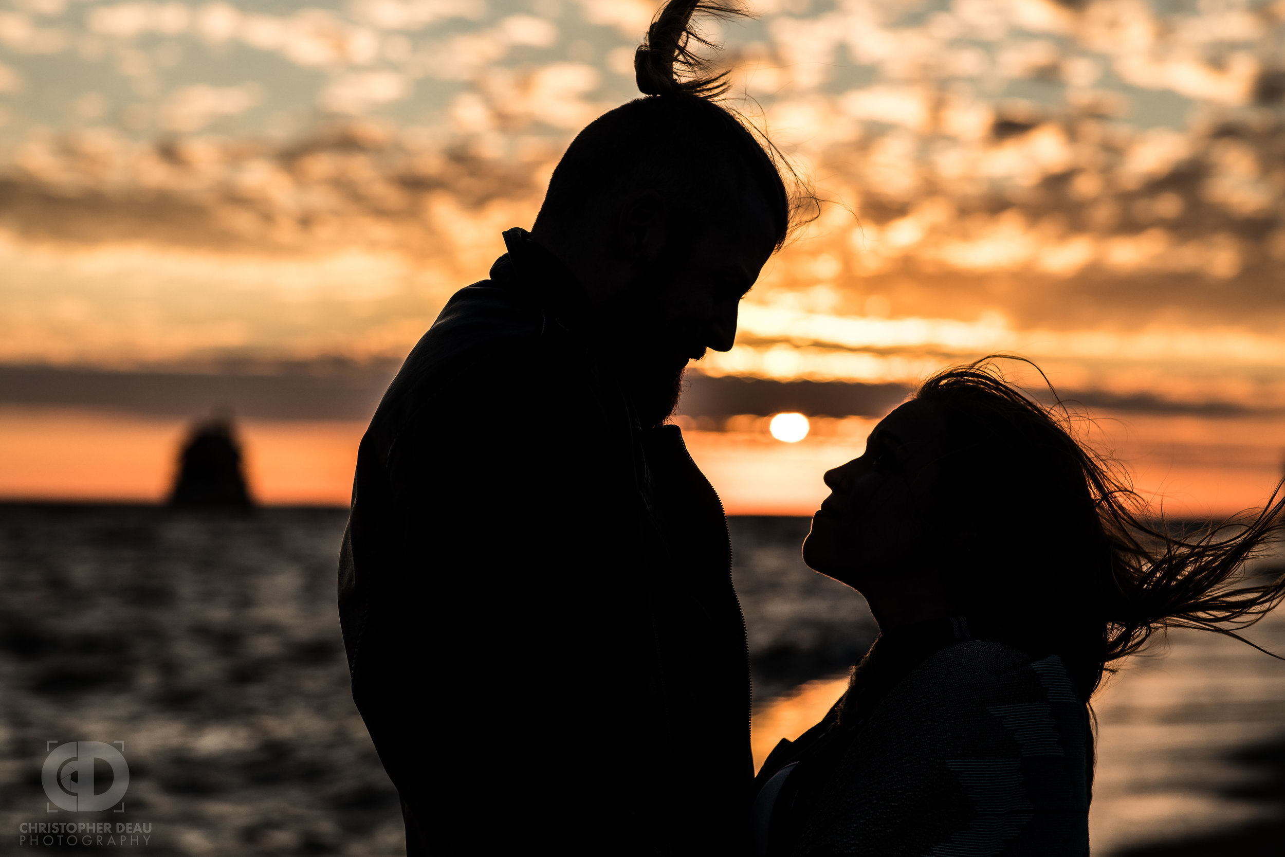  A silhouette of an engaged couple on a lake Michigan pier in Northern Michigan  