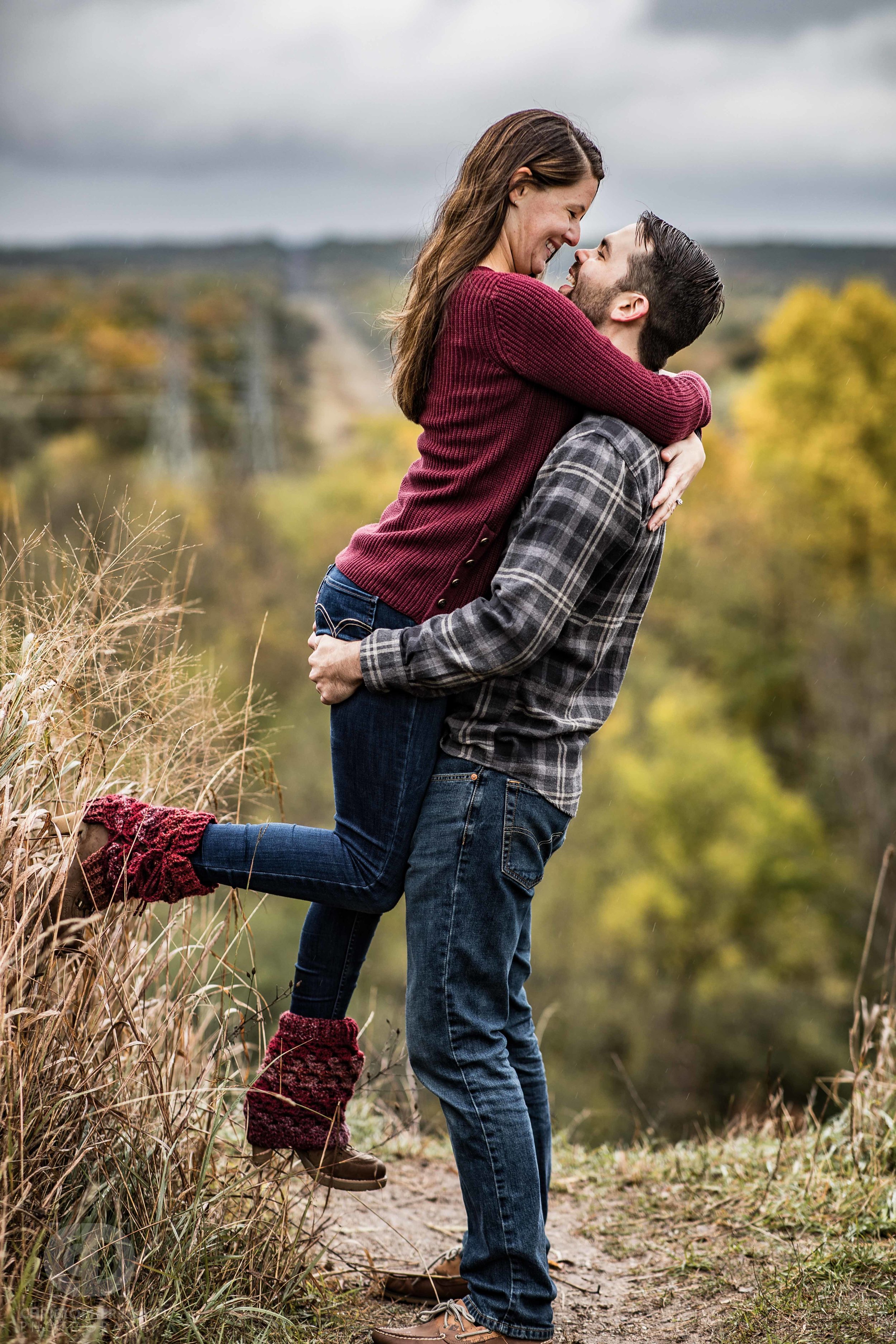  man picking up woman to kiss her at a bluff overlook in Kalamazoo Michigan 