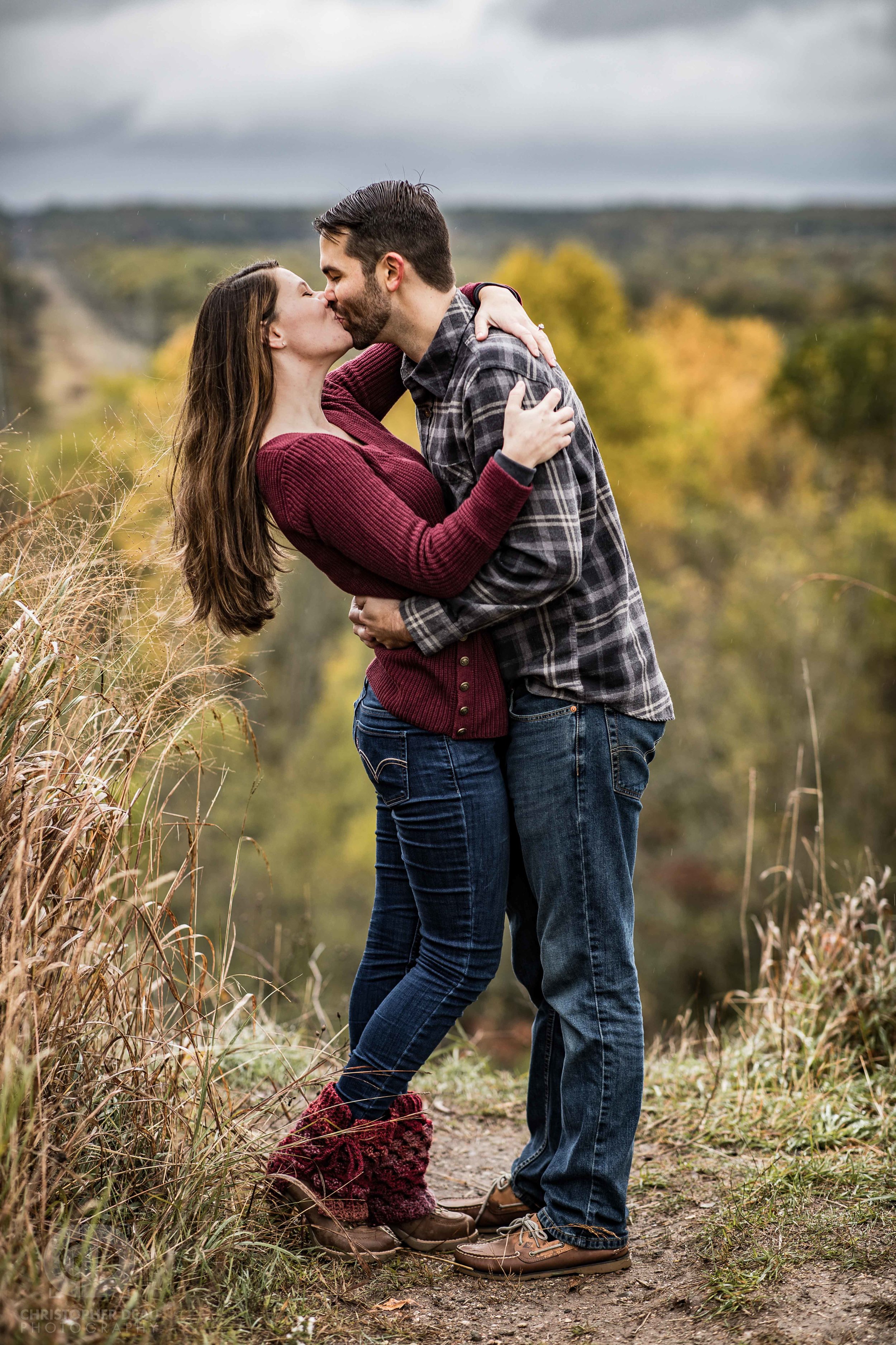  man kisses woman in front of bluff overlook at the kalamazoo nature center in southwest michigan 