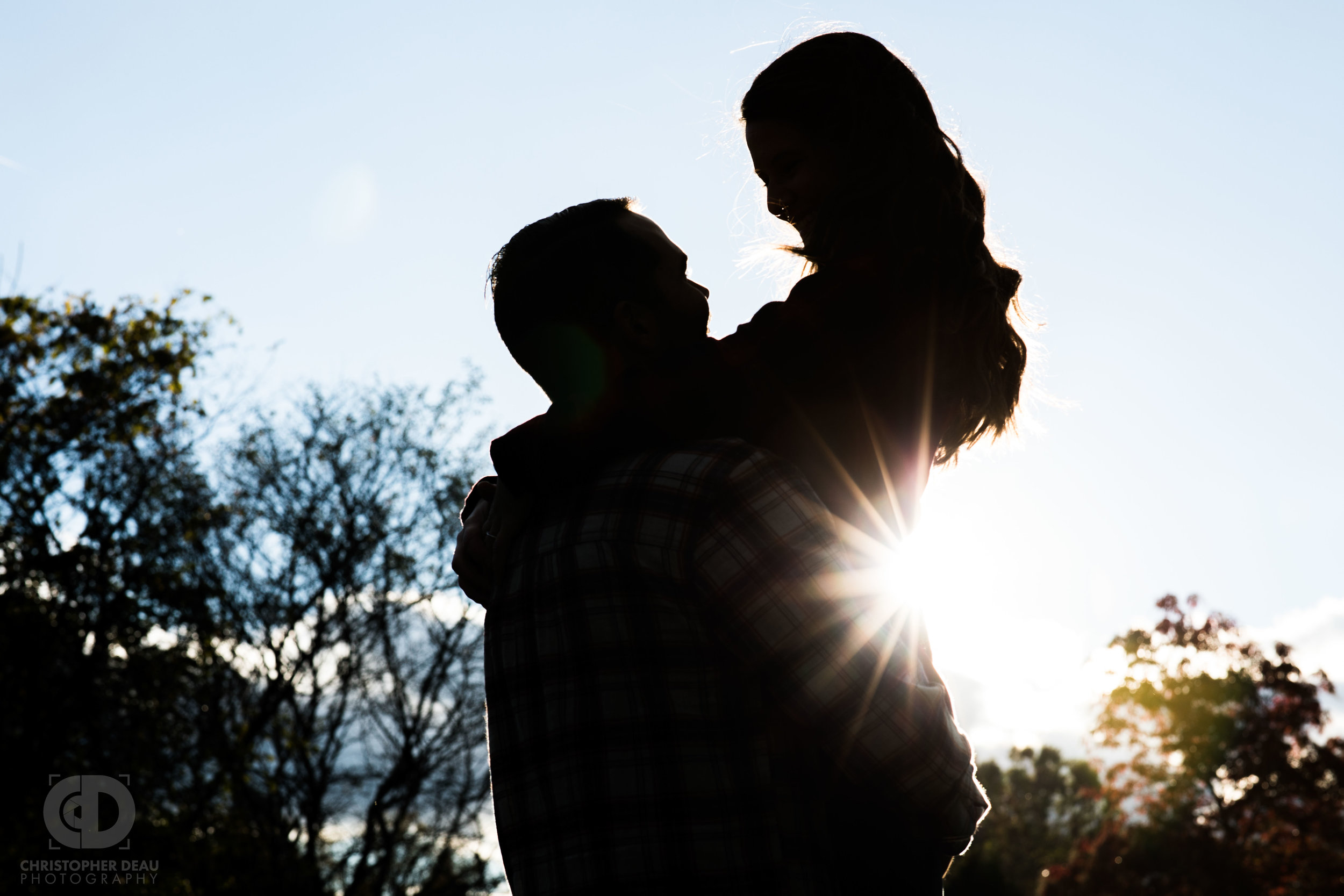  Silhouette of man lifting woman with the sun glaring behind 