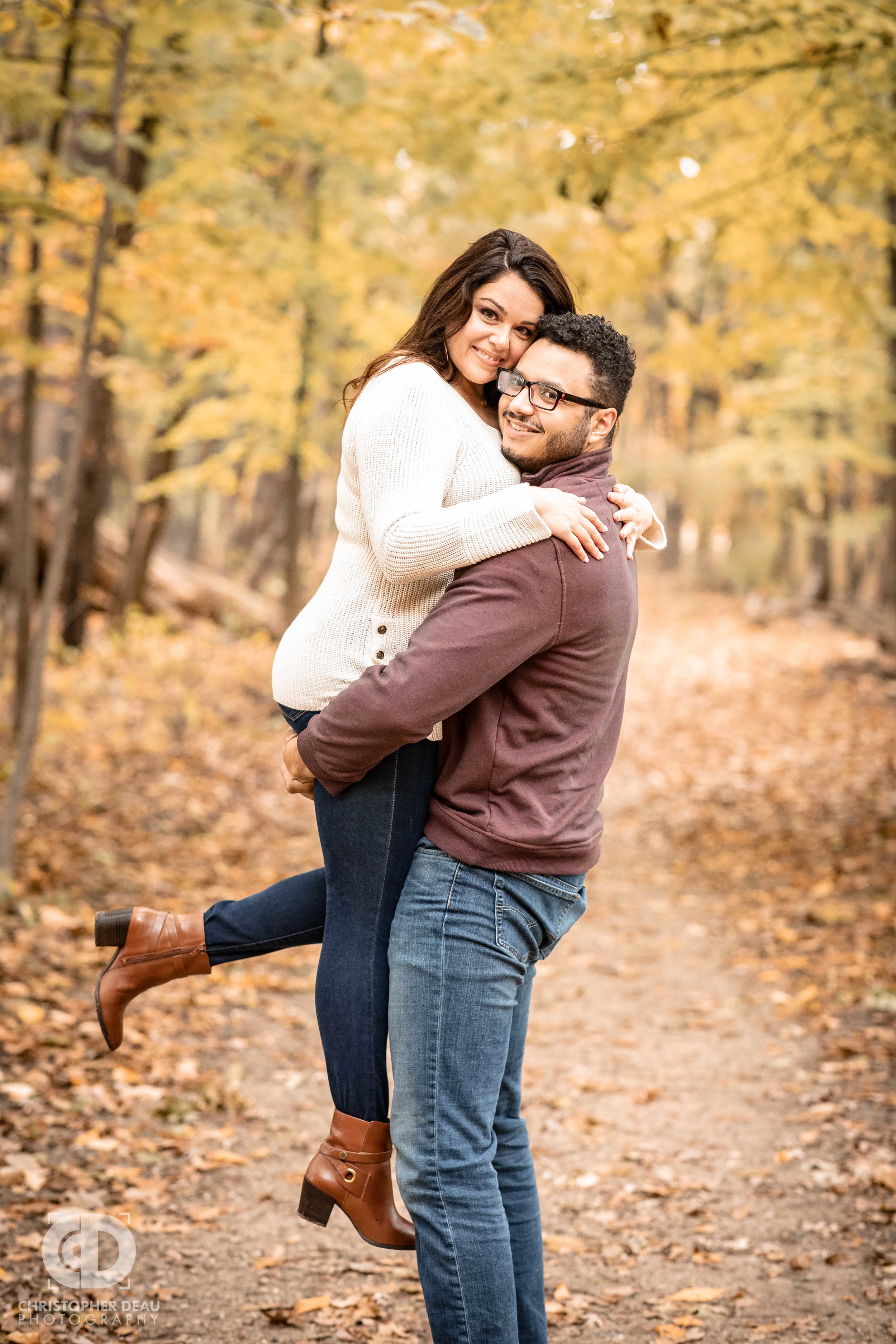  Man lifting woman for fall engagement photos 