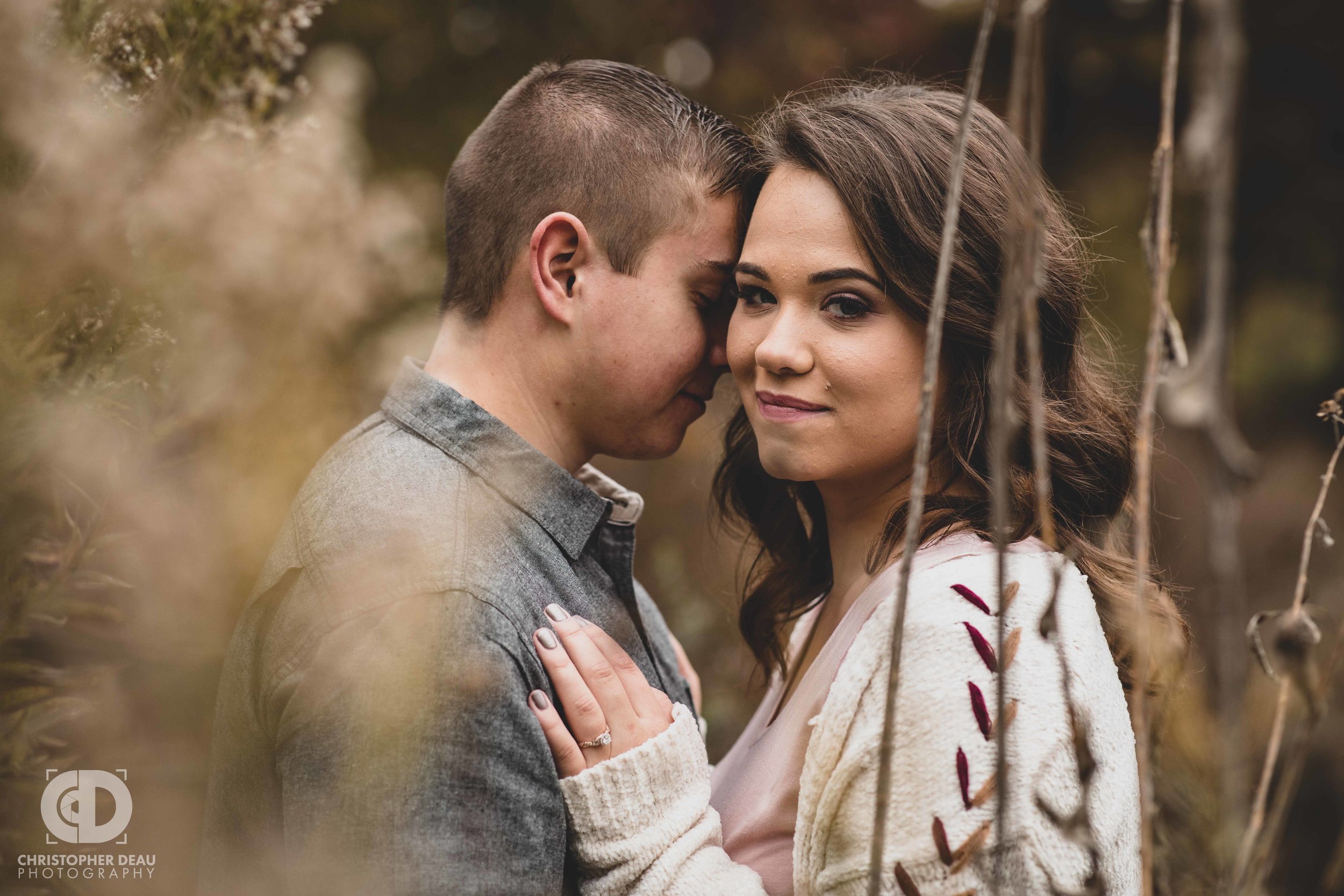  A couple holding each other in tall grass fall scene 