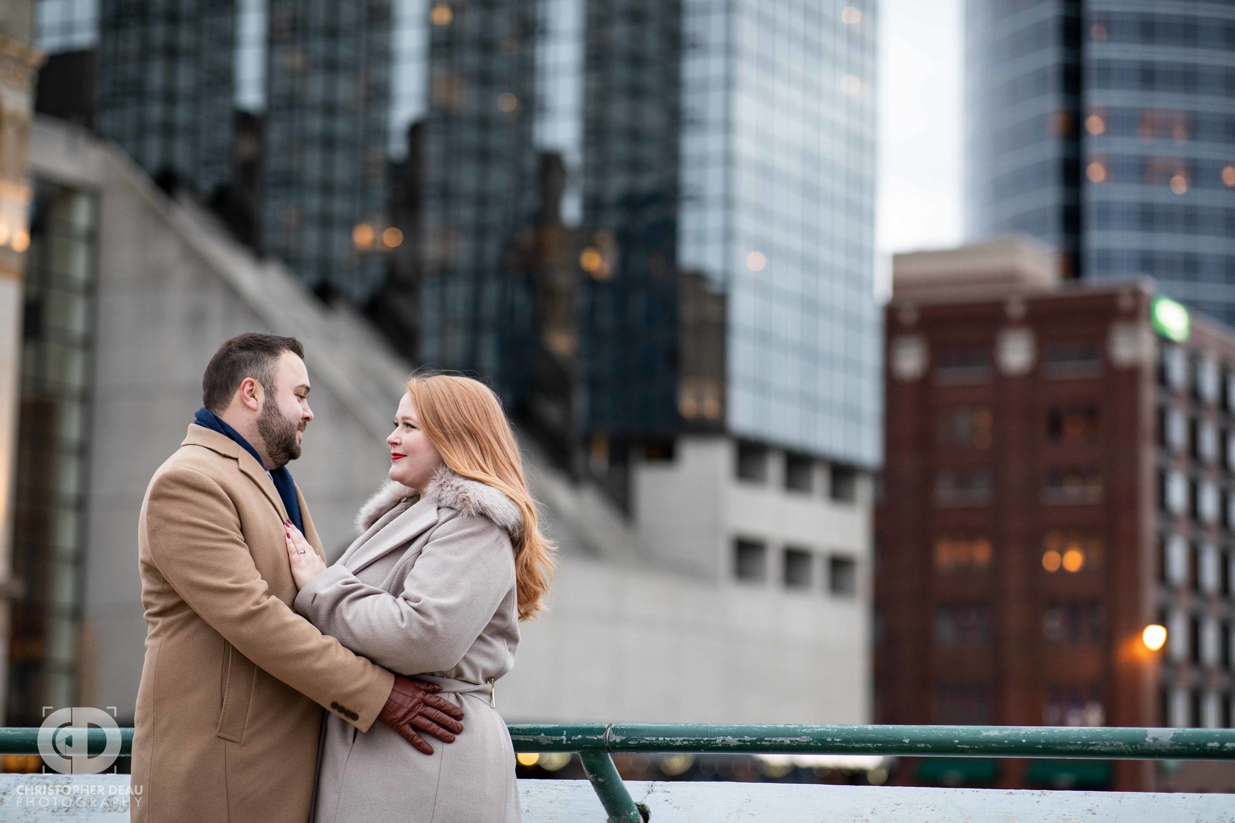  Engagement session photos on a bridge over the Grand River with Grand Rapids skyline in background 