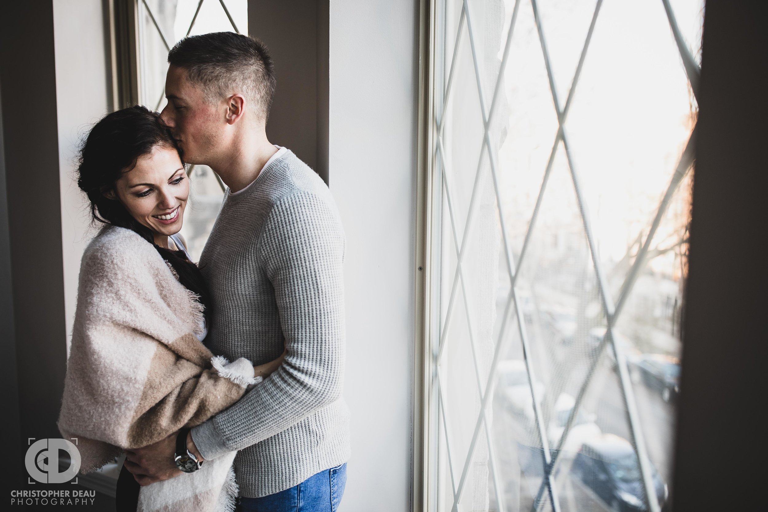  Man kissing woman during in home engagement session 