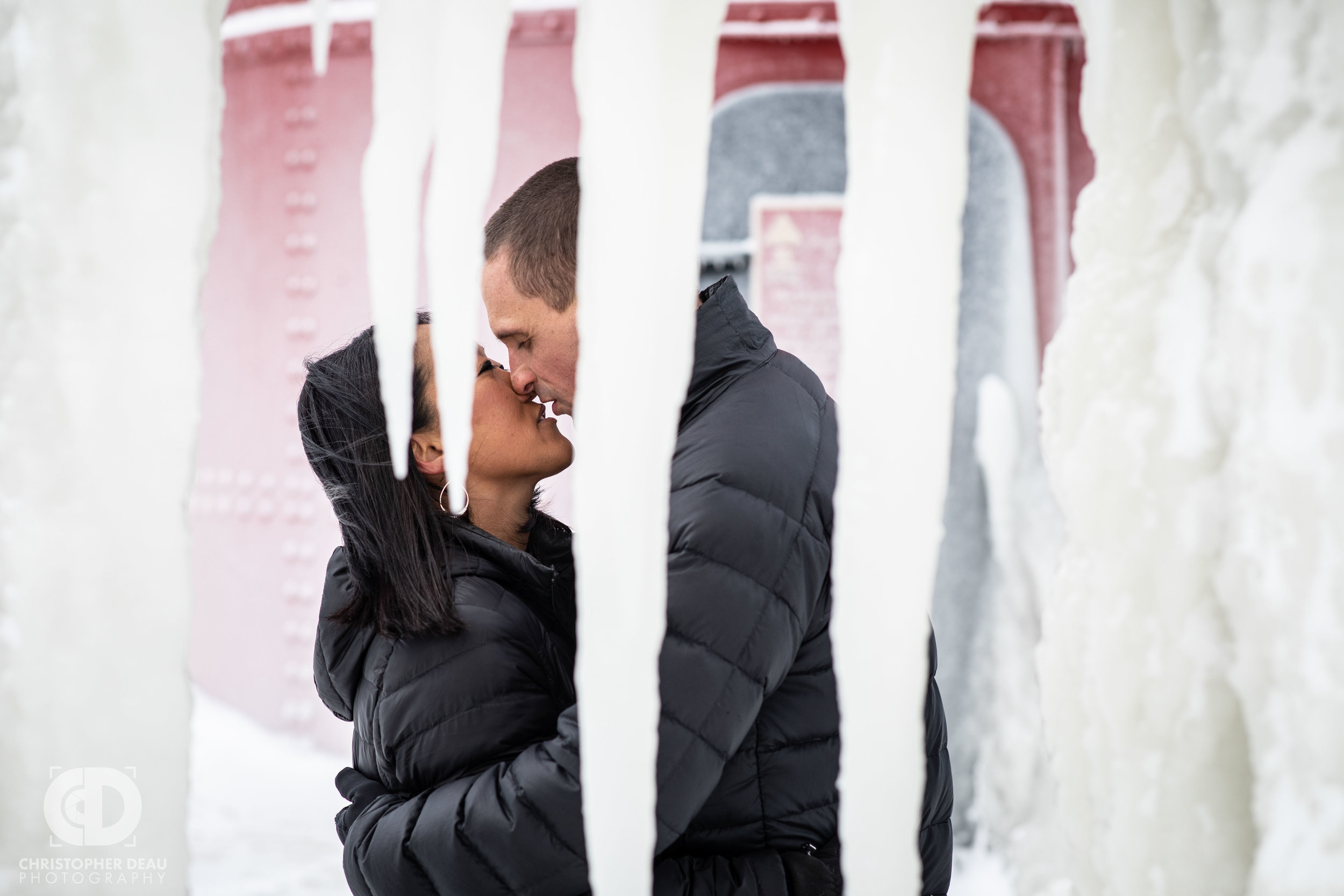  couple kissing through frozen icicles on the south haven lighthouse pier  