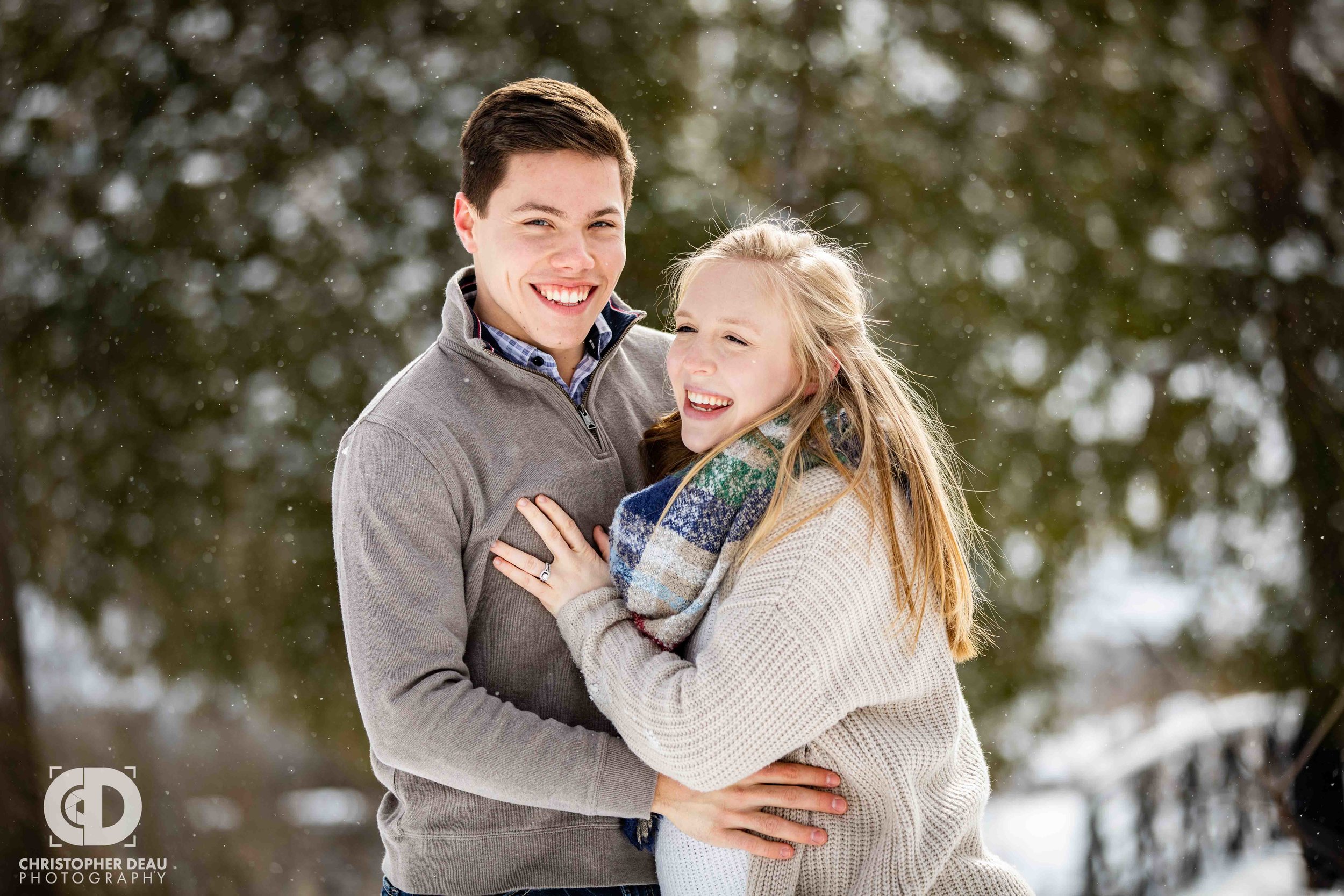 snow covered pines couples laughing during engagement photos 