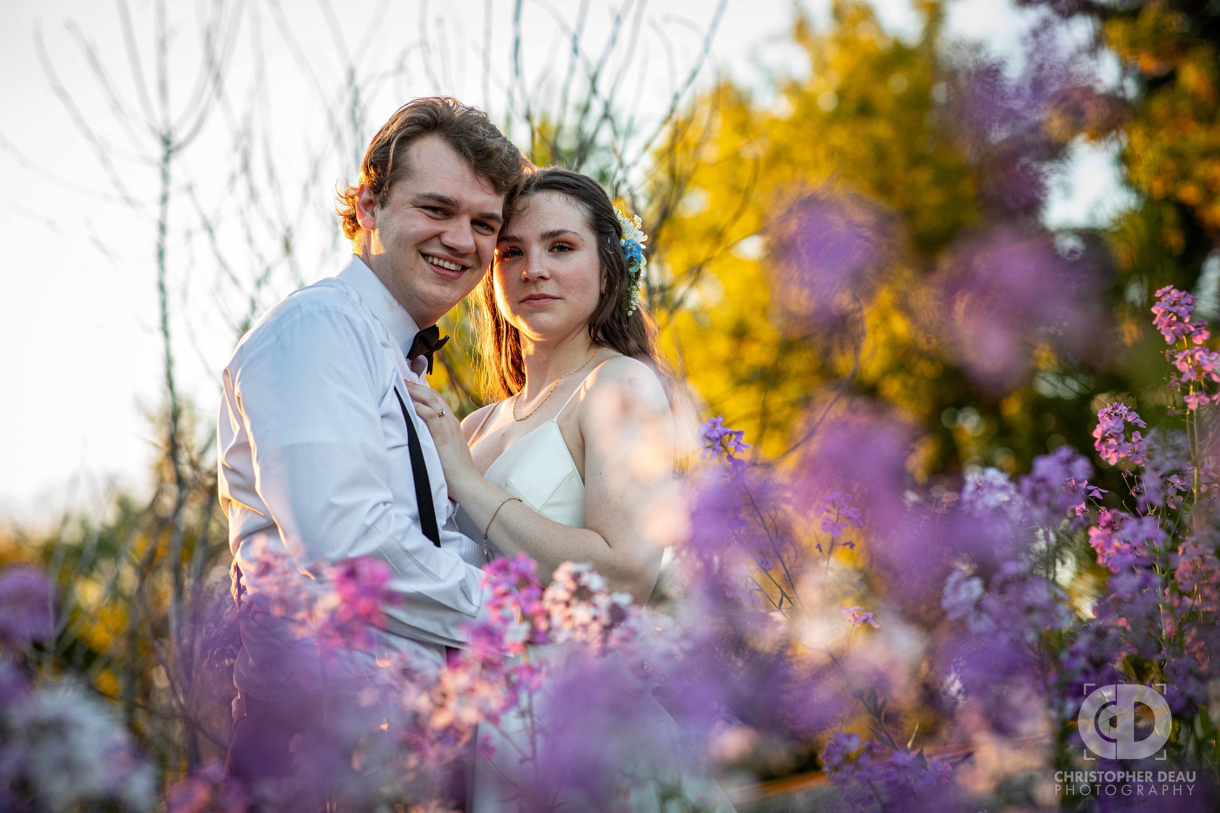  purple and white wild flowers surround bride and groom 