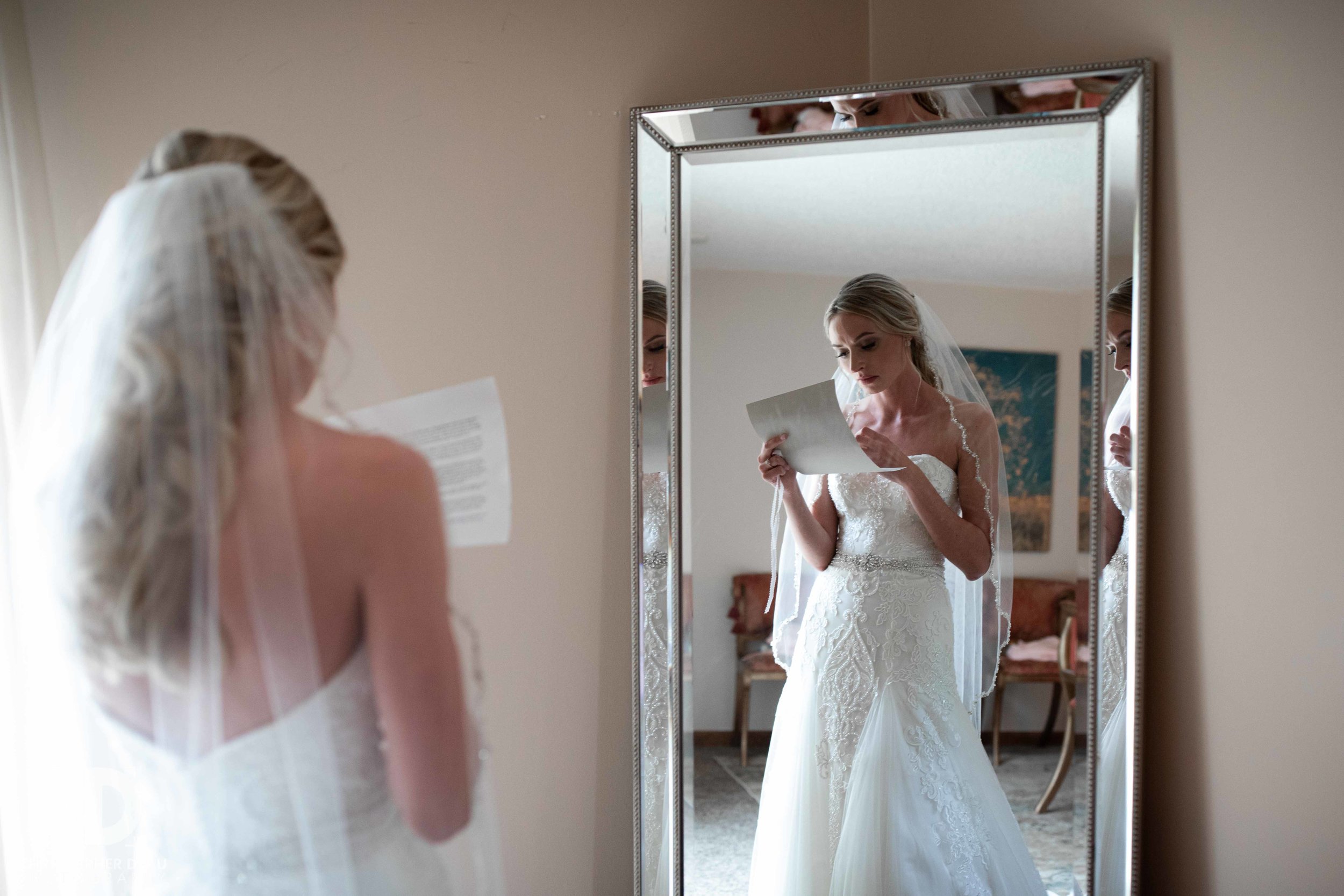  bride reading letter from the groom in front of a mirror 