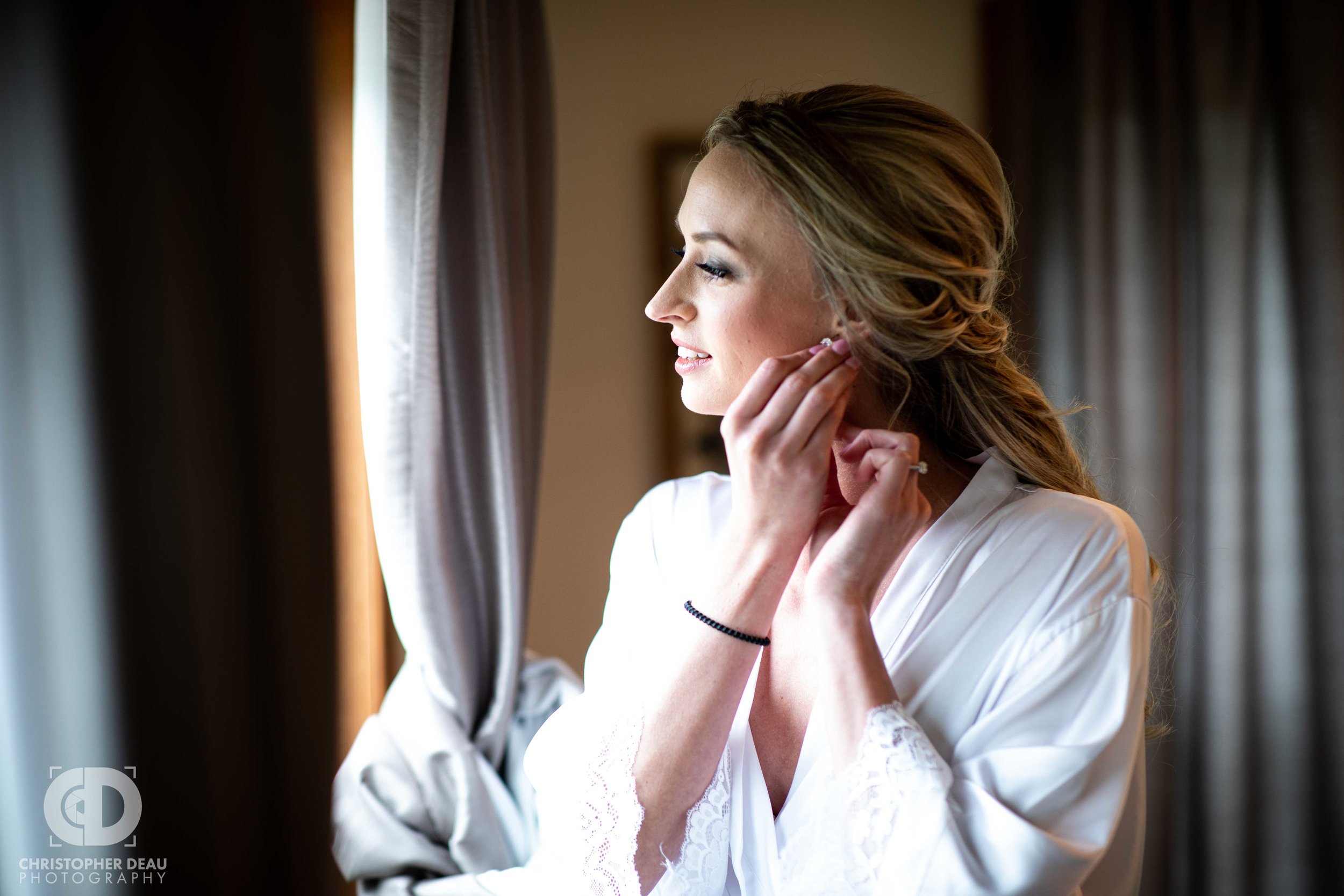  bride putting on jewelry  