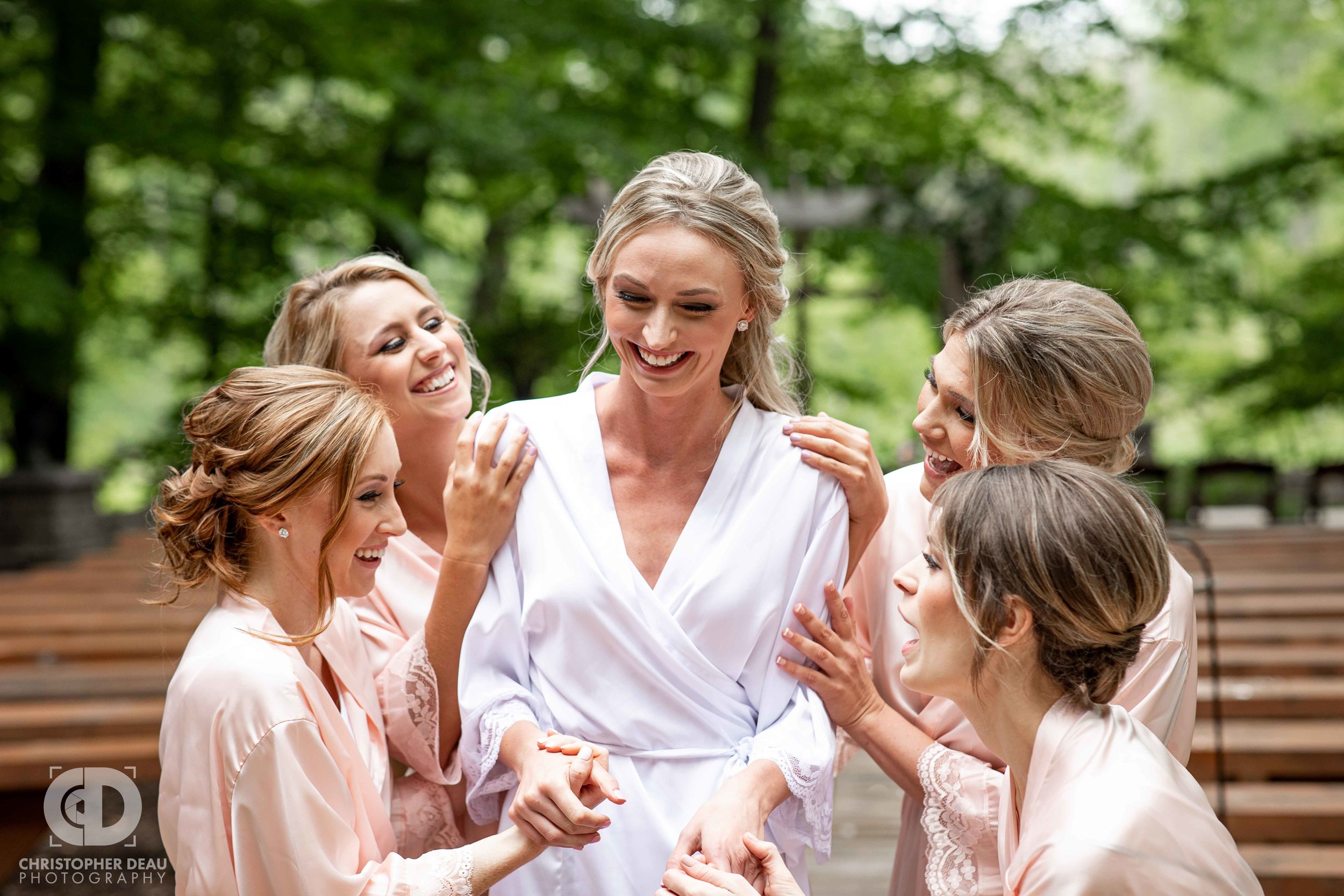  bridesmaids gushing over the bride in their robes 