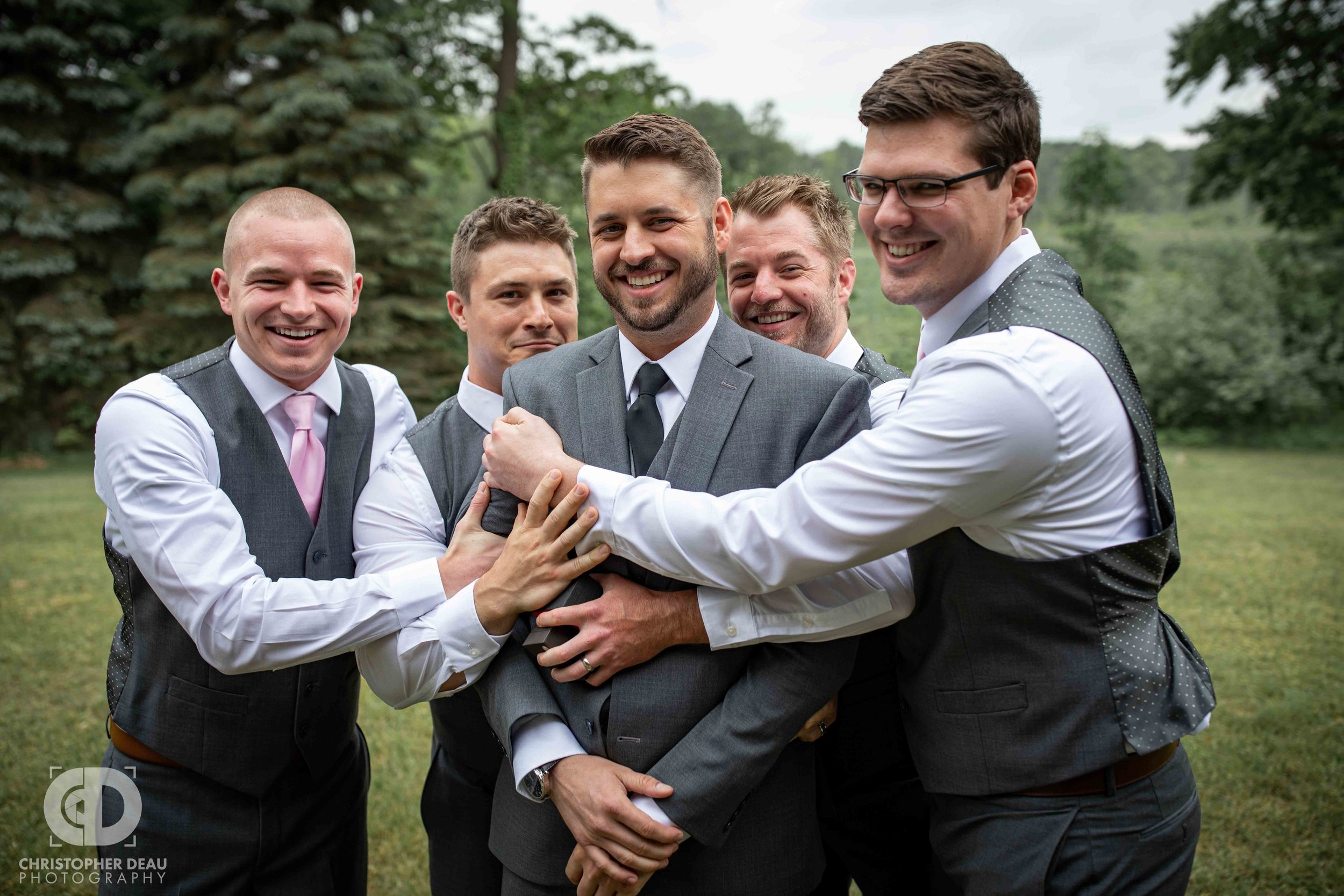  groomsmen hugging the groom 