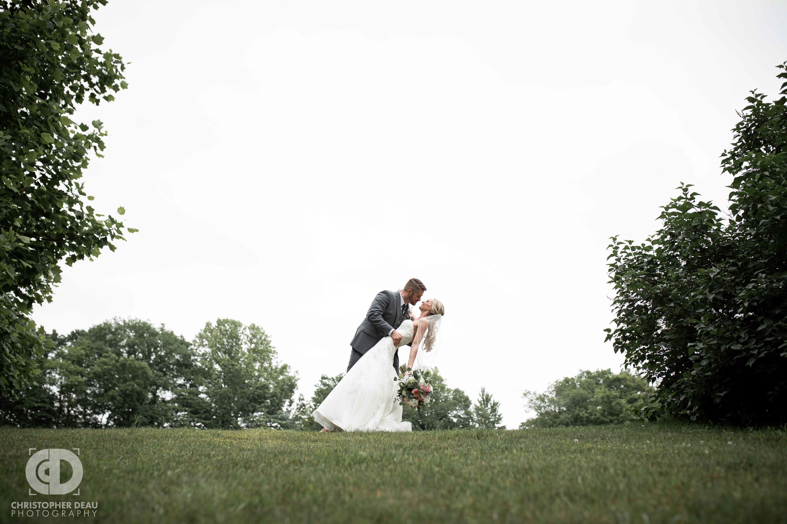  groom dips bride on hill at gable hill wedding venue 