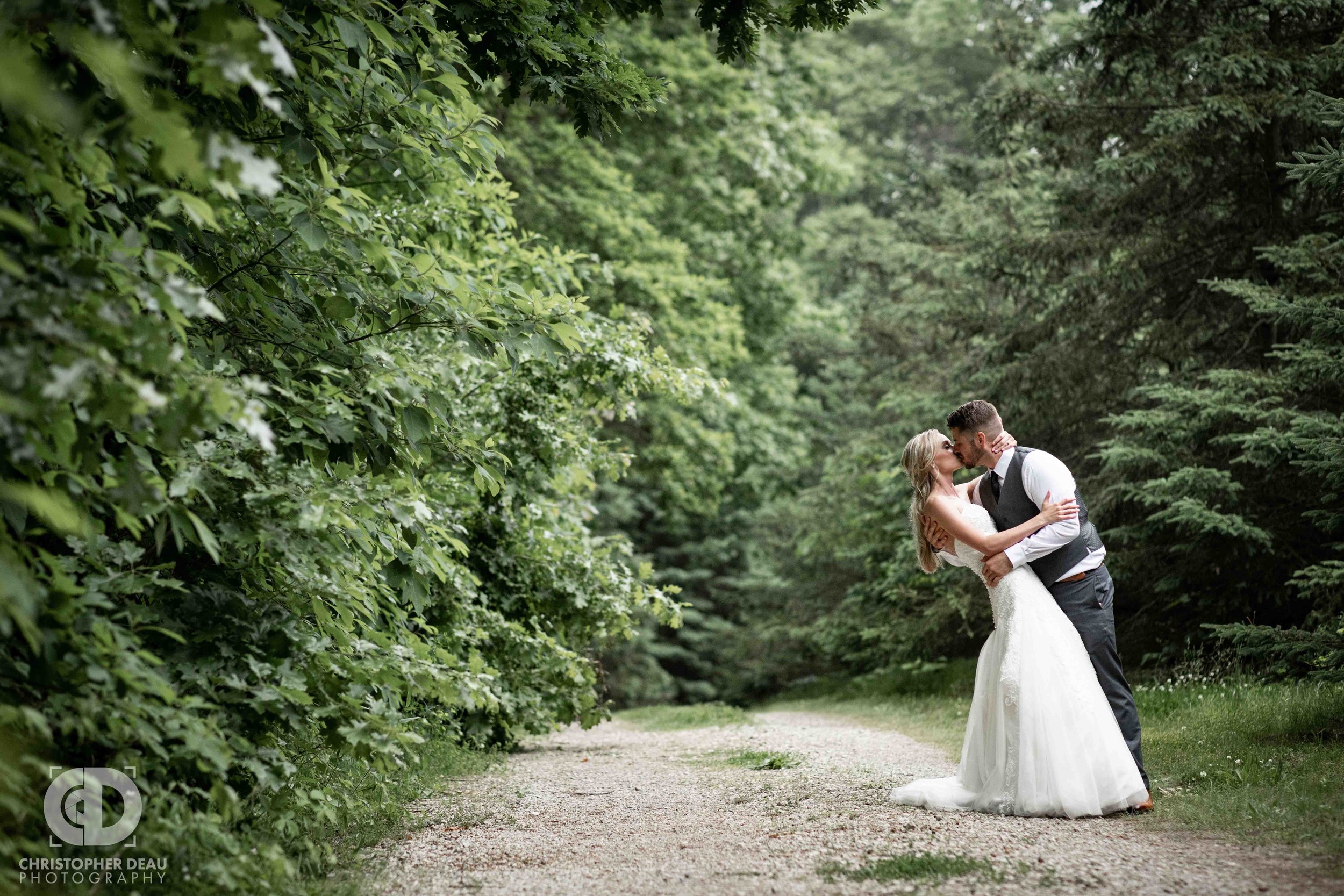  bride and groom on a dirt road with pine trees at Gable Hill 