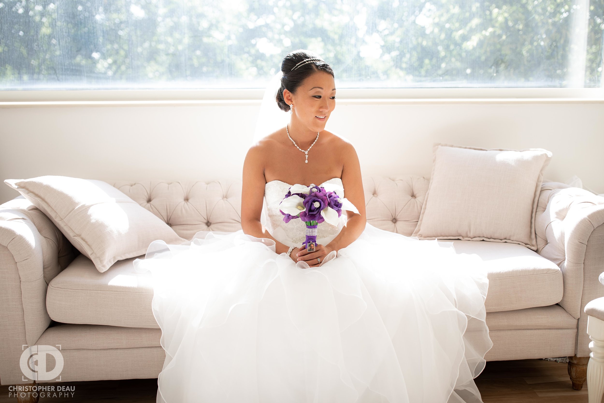  Bride with bouquet on a couch at the WMU Fetzer Center bridal suite 