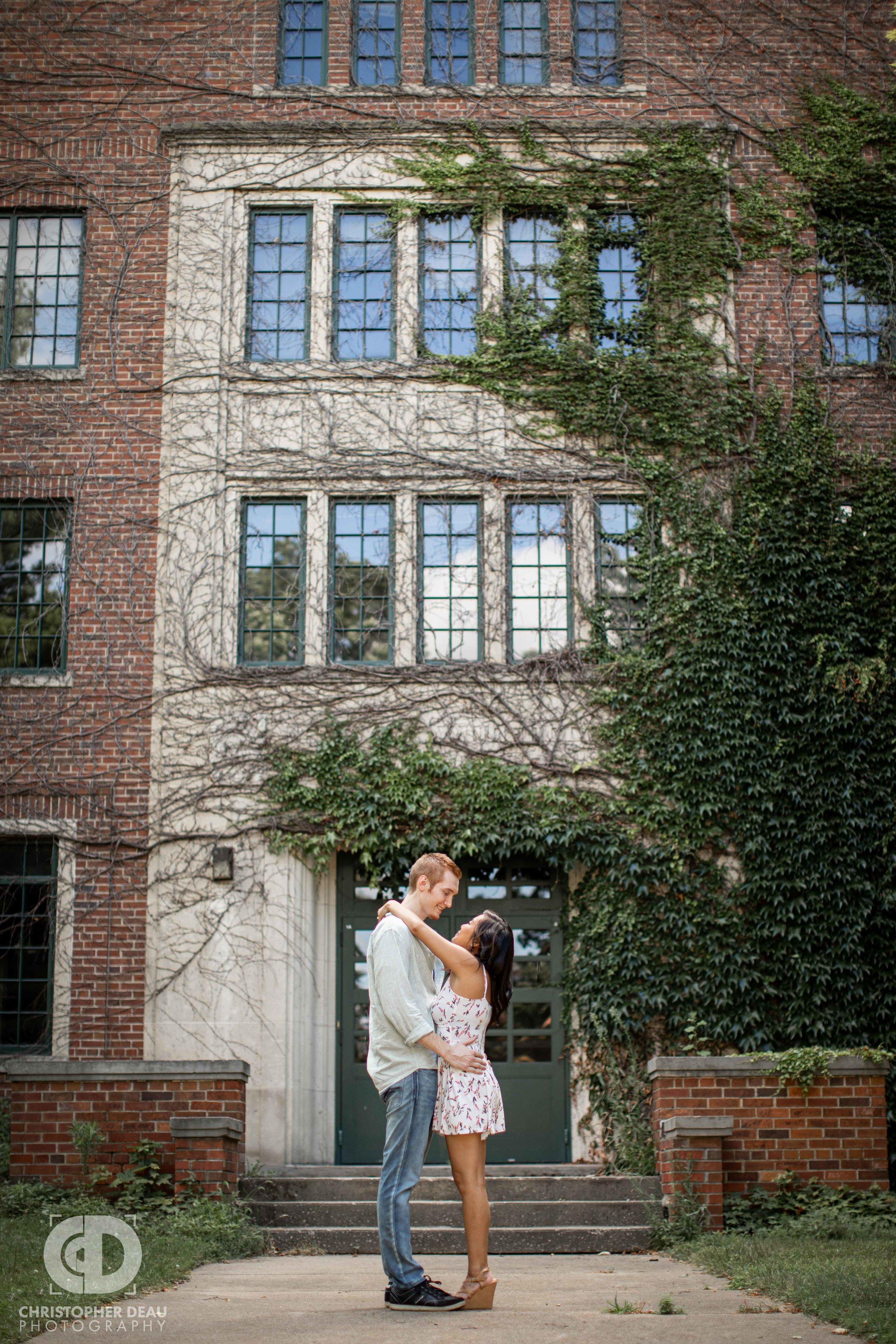  engaged couple in front of ivy covered building in Kalamazoo during photo session 