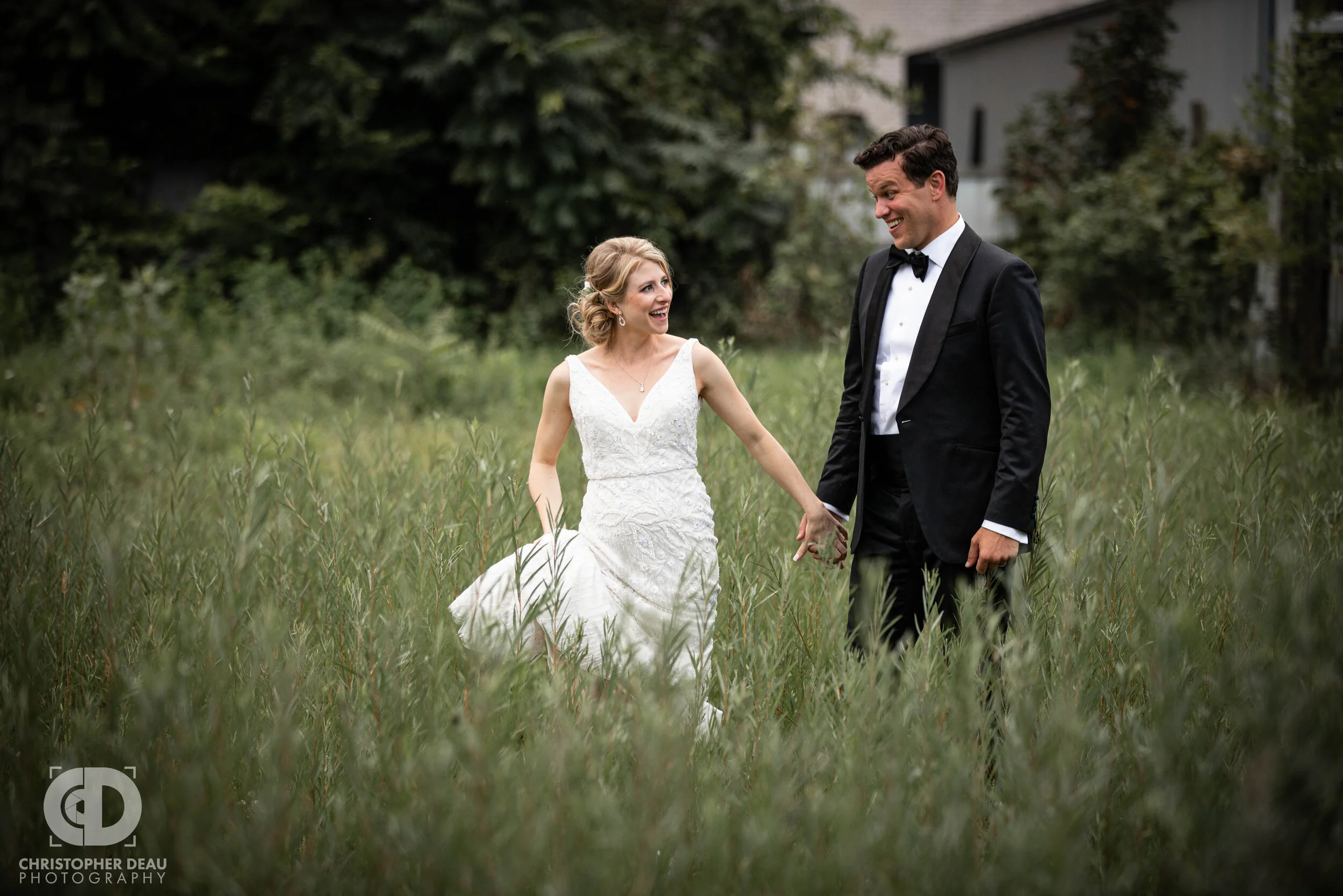 bride and groom in tall grass at journeyman distillery