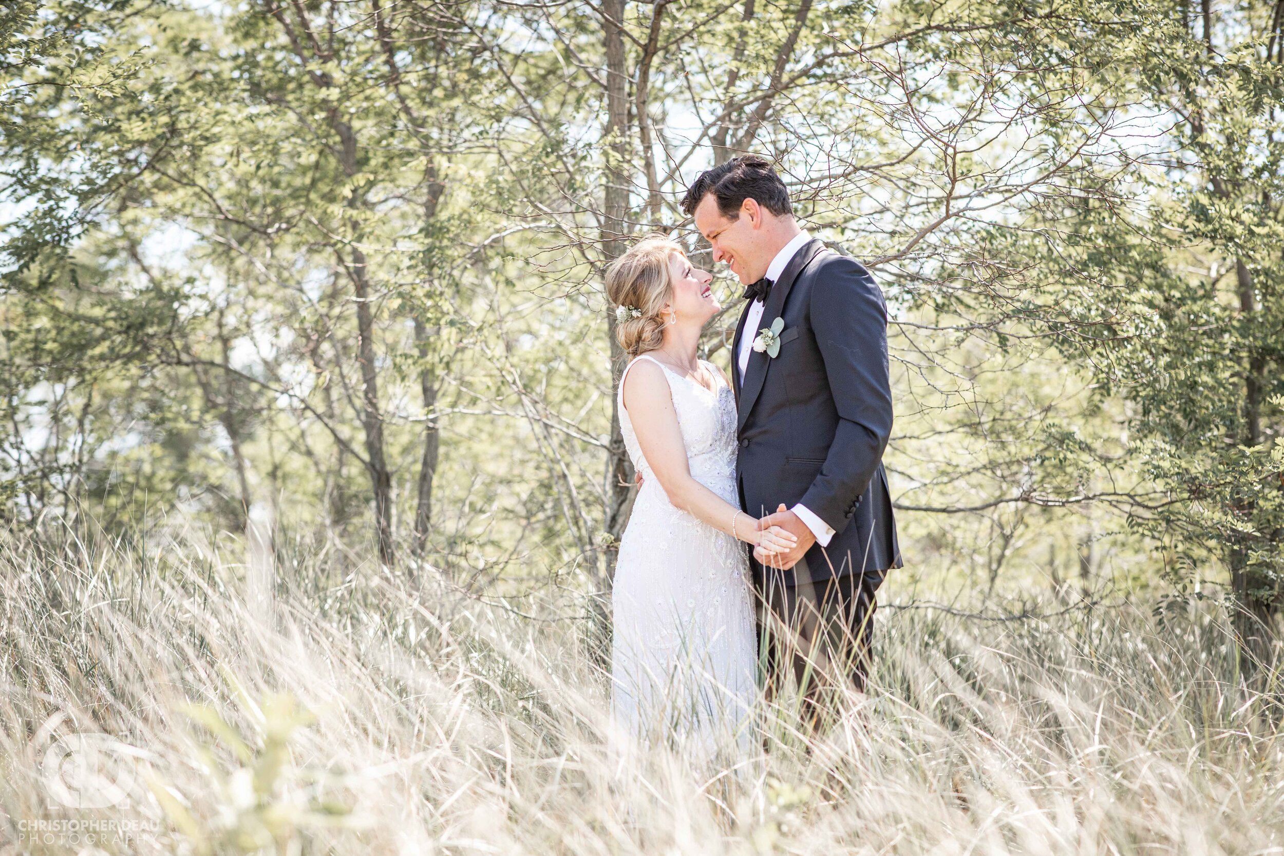  bride and groom look into each others eyes in the beach grass of Lake Michigan 