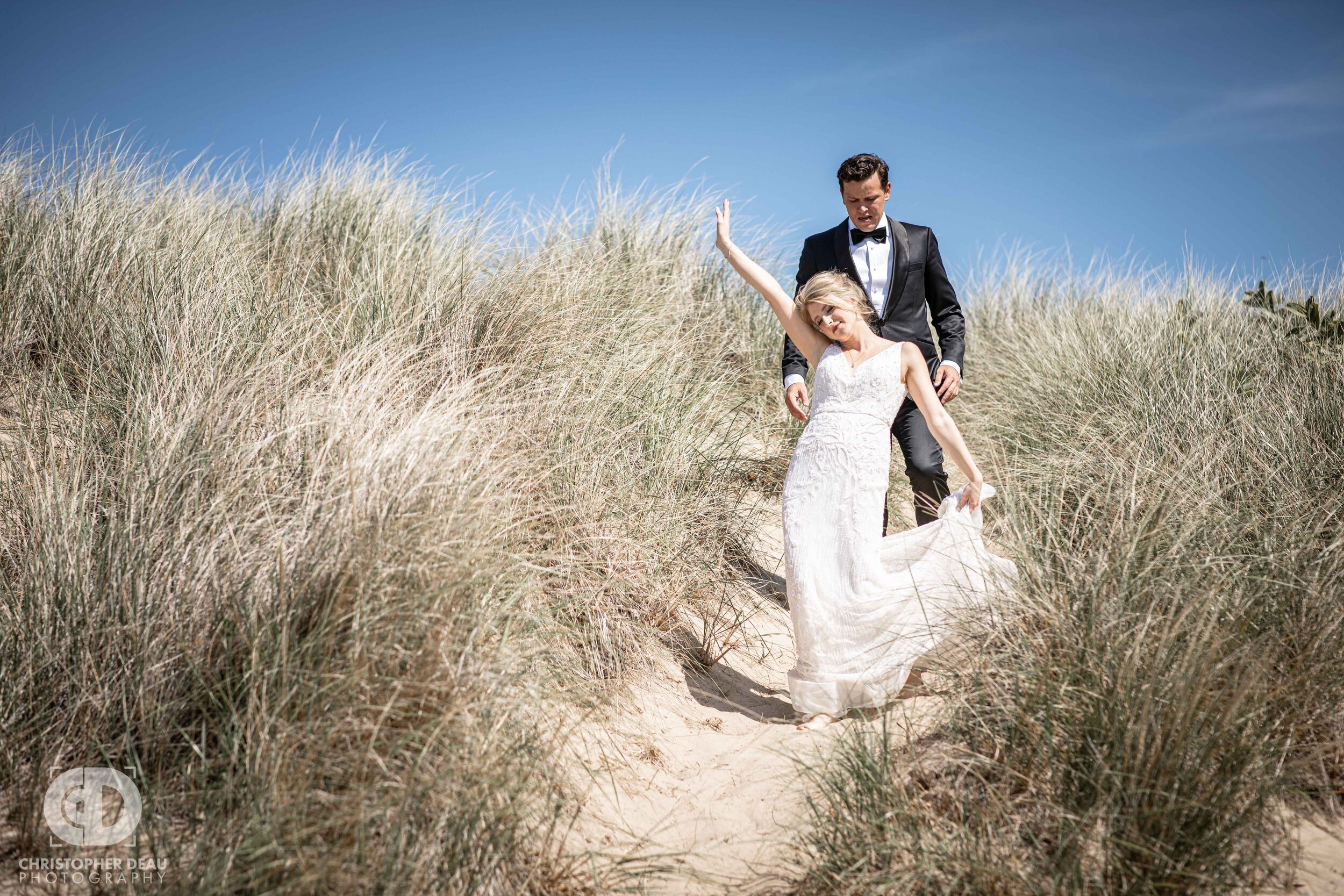  bride and groom descending a lake michigan sand dune 