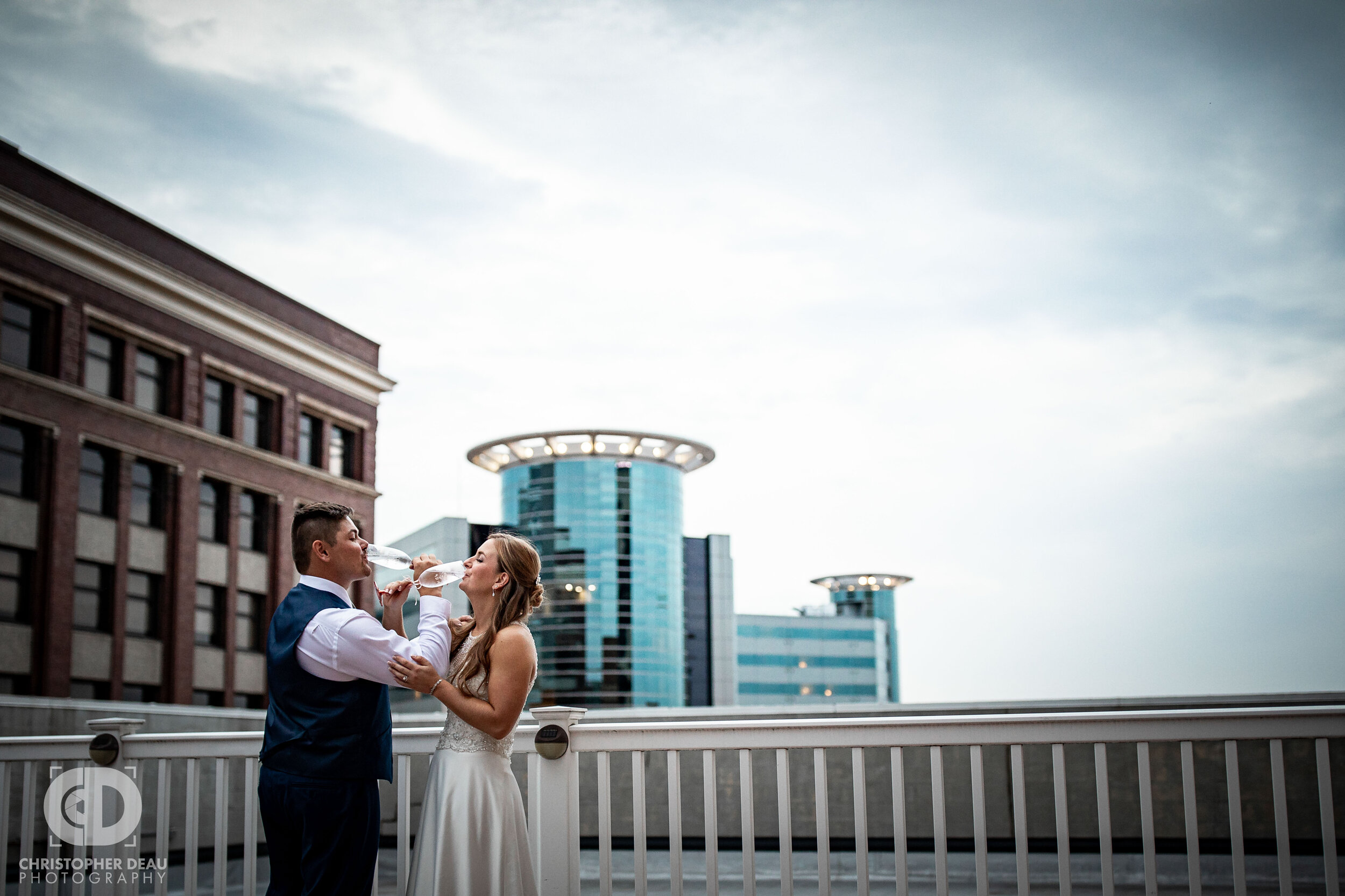  a rooftop toast with the bride and groom at cityscape in kalamazoo 
