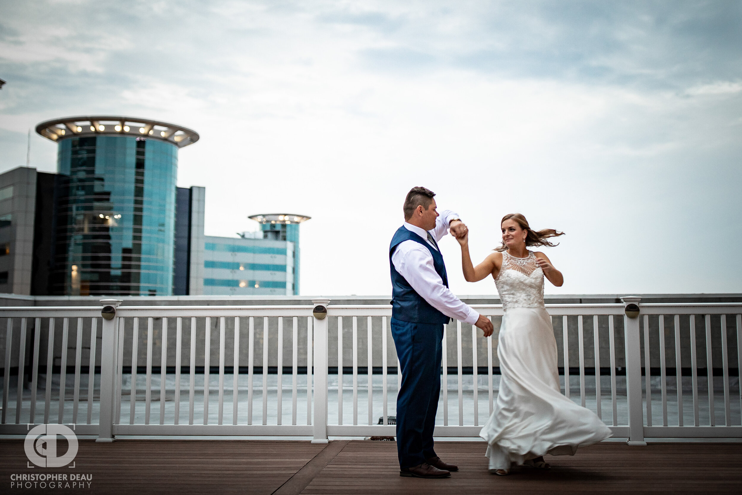  groom spins the bride on the rooftop of cityscape in Kalamazoo Michigan 