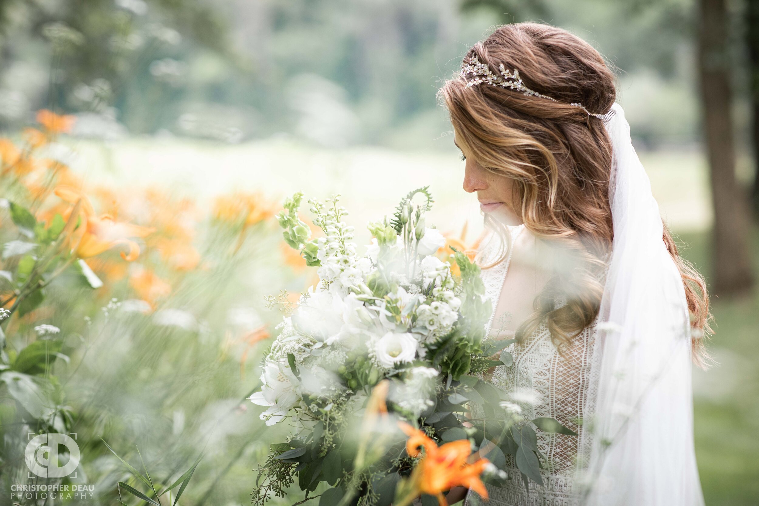  beautiful flowers surrounding a bride as she smells her bouquet  