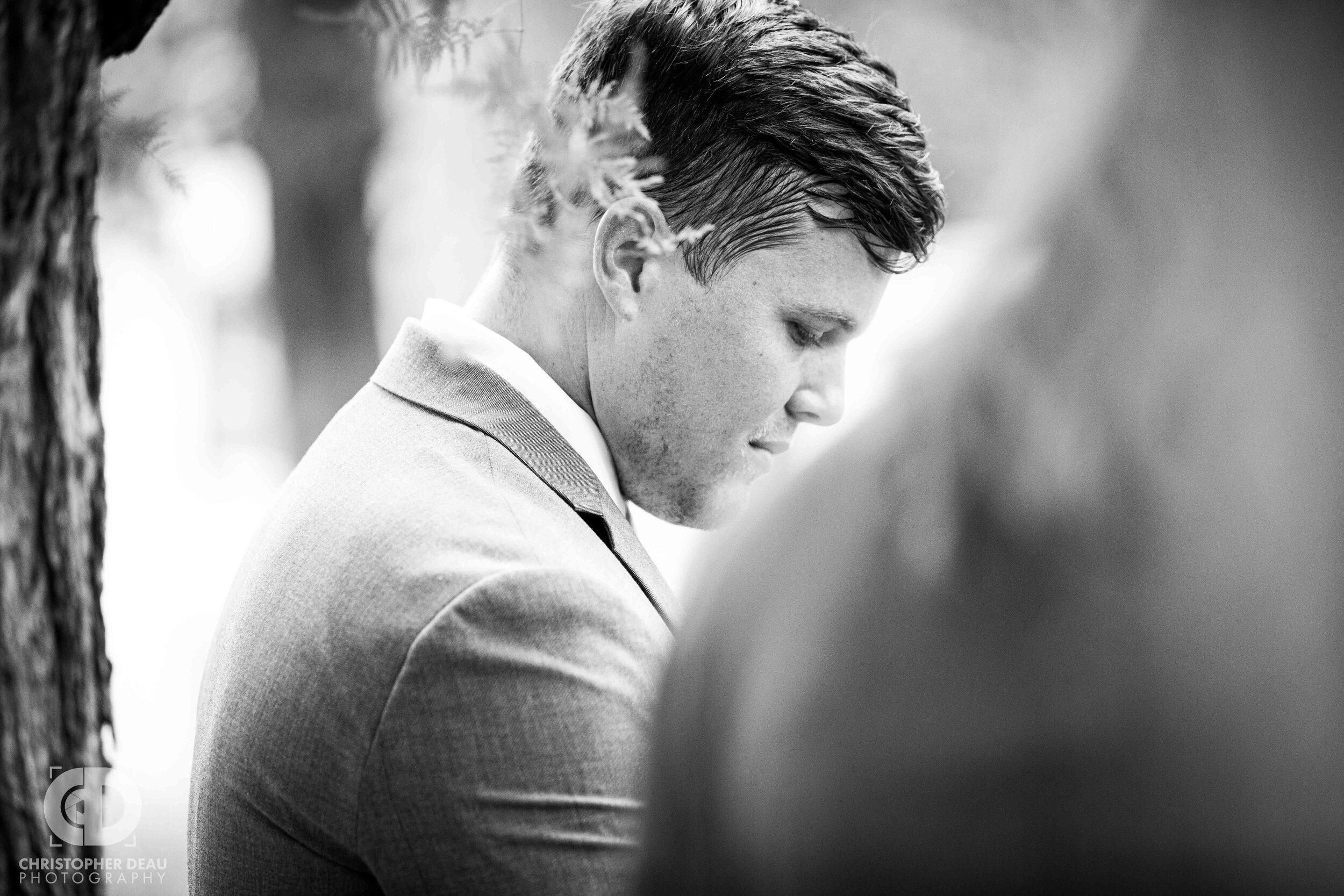  groom nervously awaits his bride as she walks down the aisle  