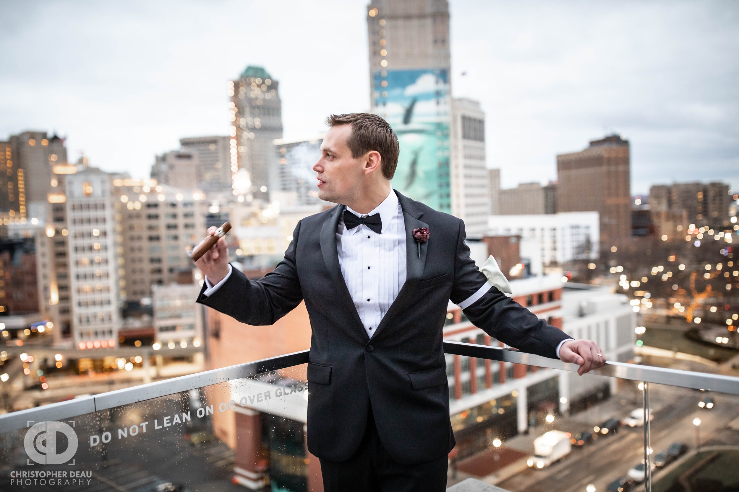  Groom with a cigar overlooking the city of Detroit via rooftop 