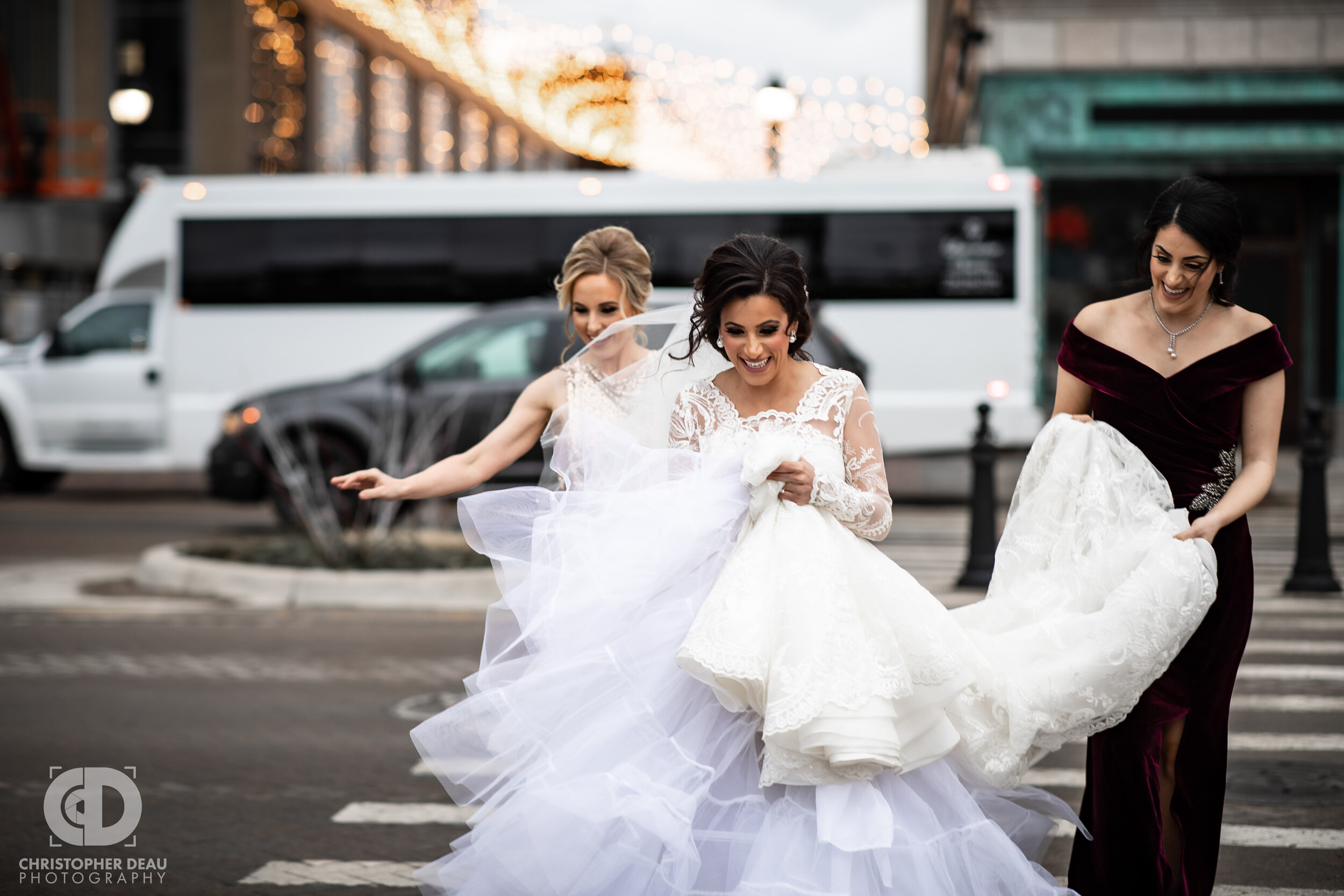  The bridesmaids hold the bride’s dress as they run across a downtown Detroit street 