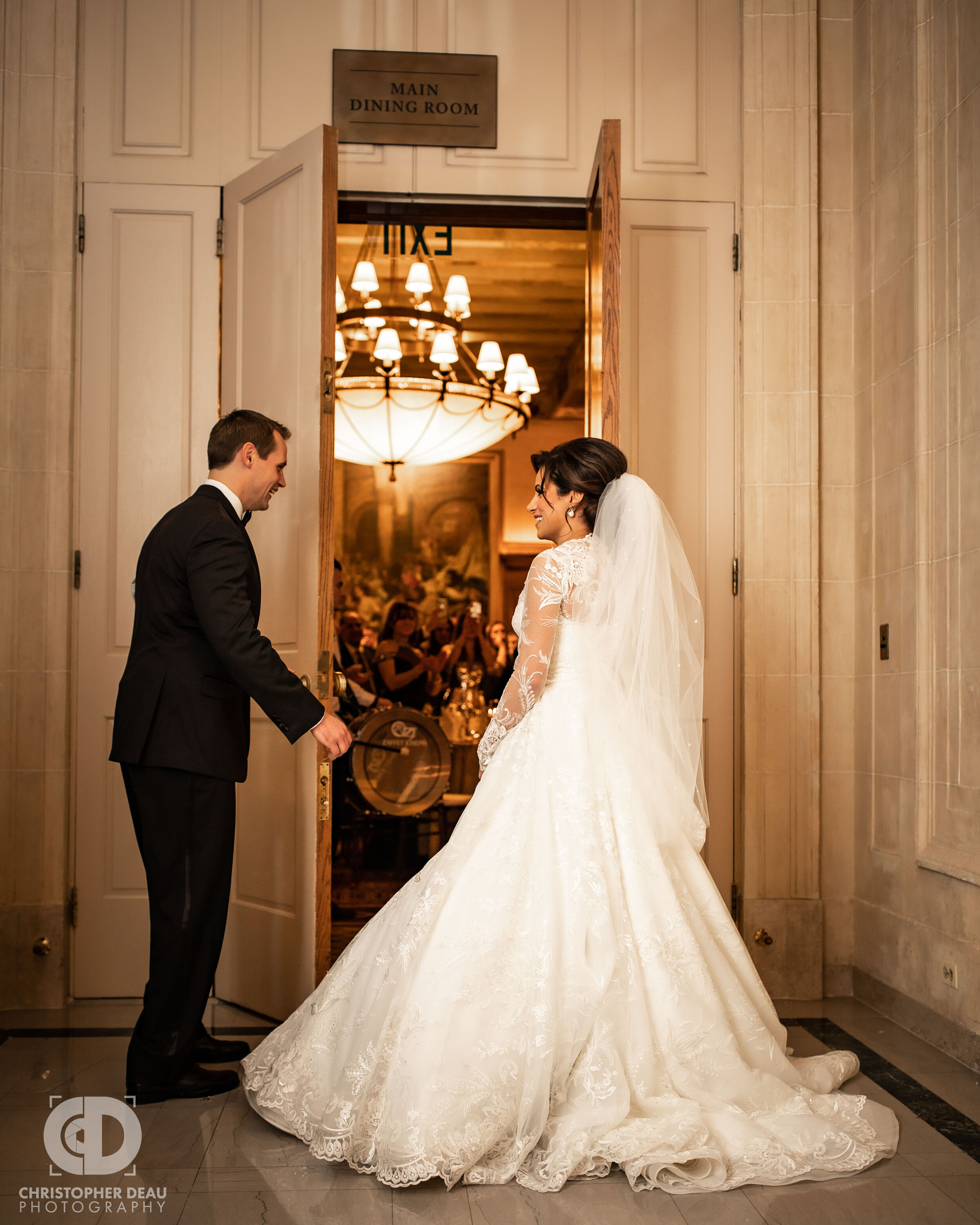  The bride and groom open double doors as they walk into their reception for their grand entrance 