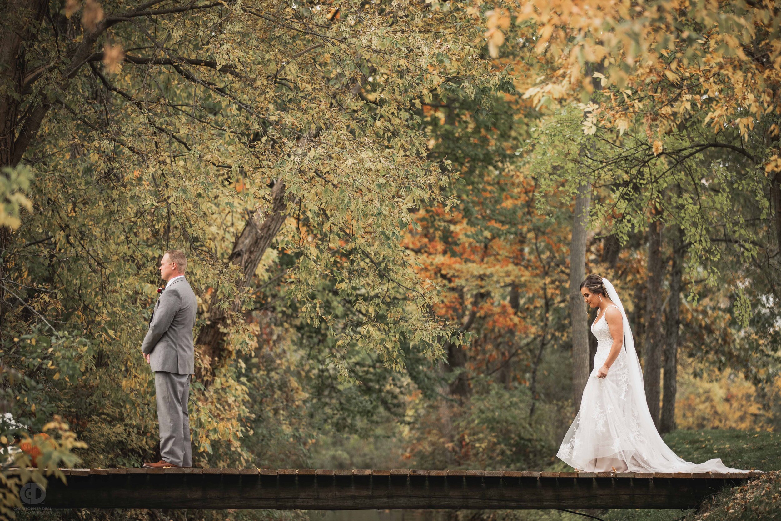  bride walks onto bridge over a stream for the first look with the groom 